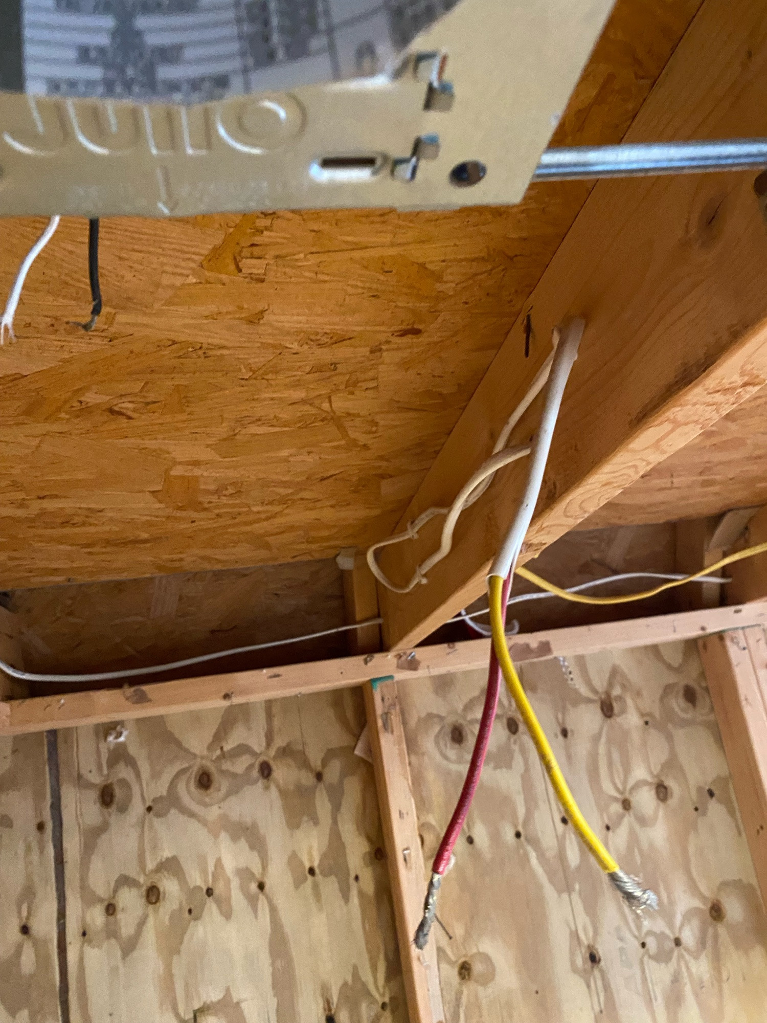 A photo of a marine rated electrical cable being used in a storage building. it connected side by side fixtures but instead of being a straight run, a loop was pulled back and stapled in place.