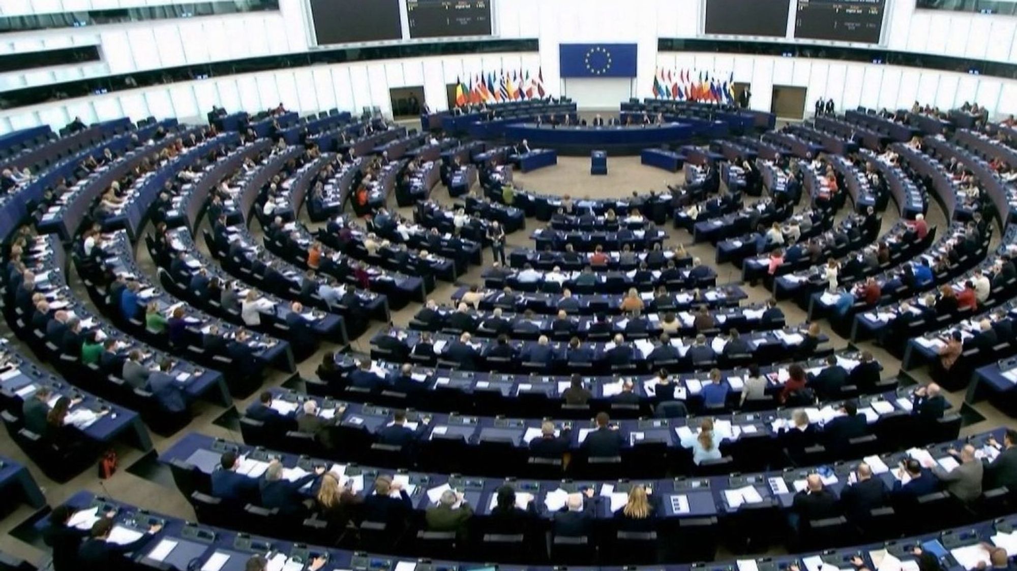 Une séance au parlement européen. On observe l'amphithéâtre, où les députés sont en séance, en hauteur depuis sa périphérie, face à l'estrade.