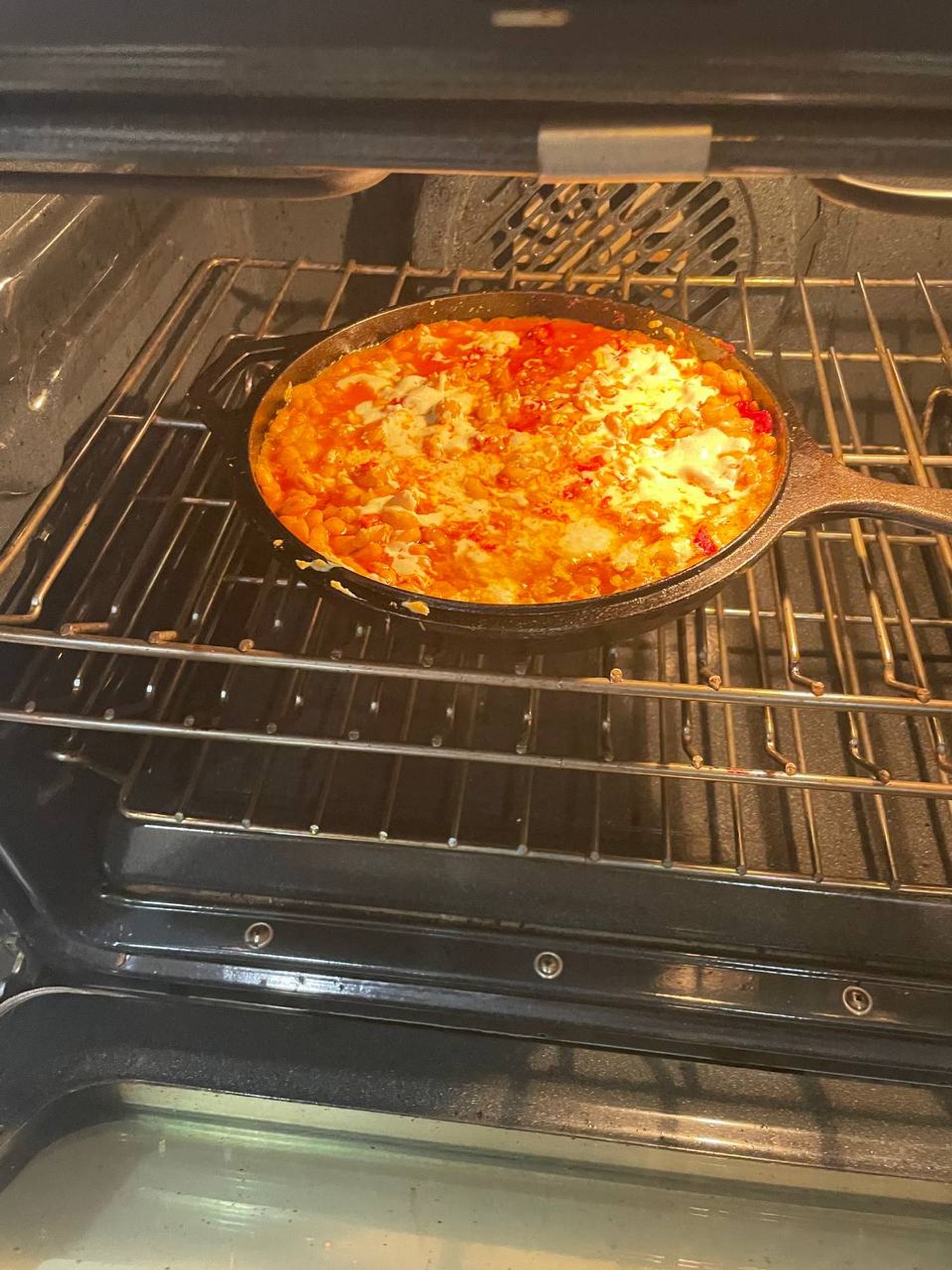 a picture of the meal before I pulled it out of the oven and almost burnt my hand by grabbing the handle well before the cast iron pan cooled. https://web.archive.org/web/20240530060452/https://cooking.nytimes.com/recipes/1019681-cheesy-white-bean-tomato-bake