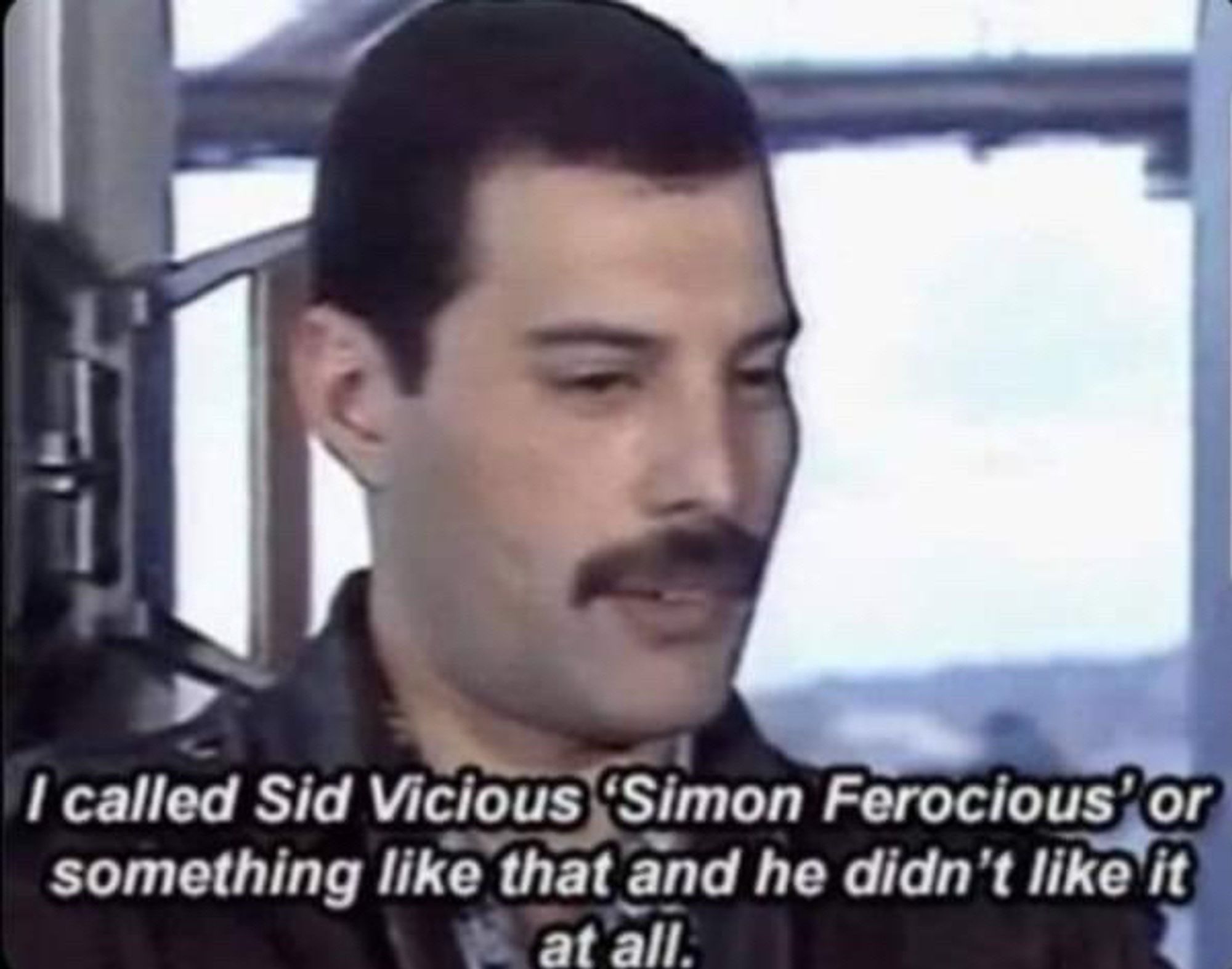 Still from video of Freddie Mercury saying "I called Sid Vicious 'Simon Ferocious' or something liked that and he didn't like it at all"