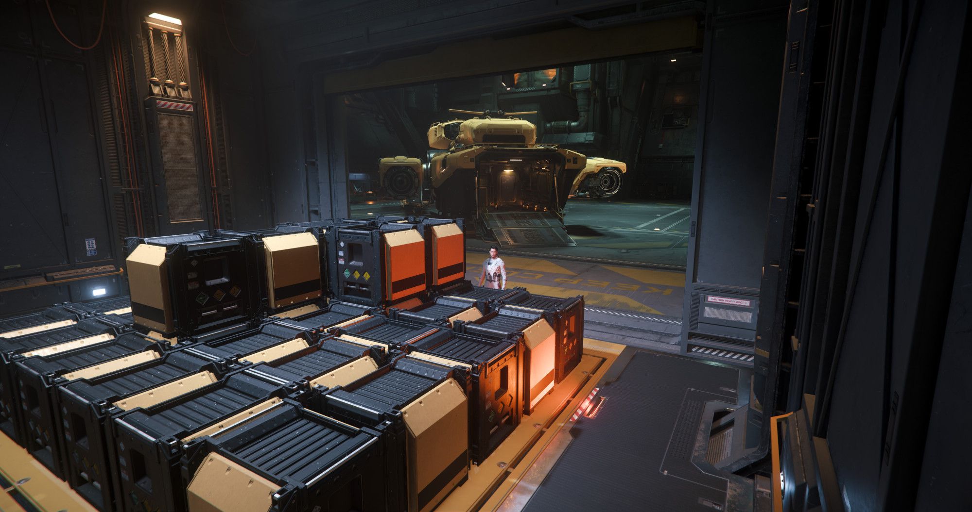 A player character in a white suit stands behind yellow and black cargo boxes with a yellow Drake Vulture salvage ship in the background in a hangar in the game Star Citizen.