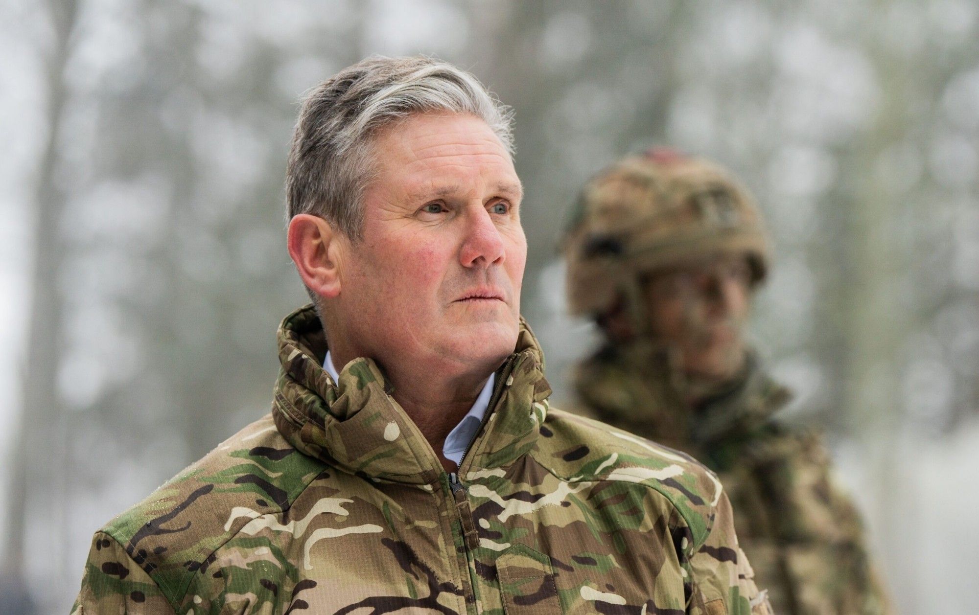 Keir starmer wearing a camo jacket over his shirt with a pained expression on his face