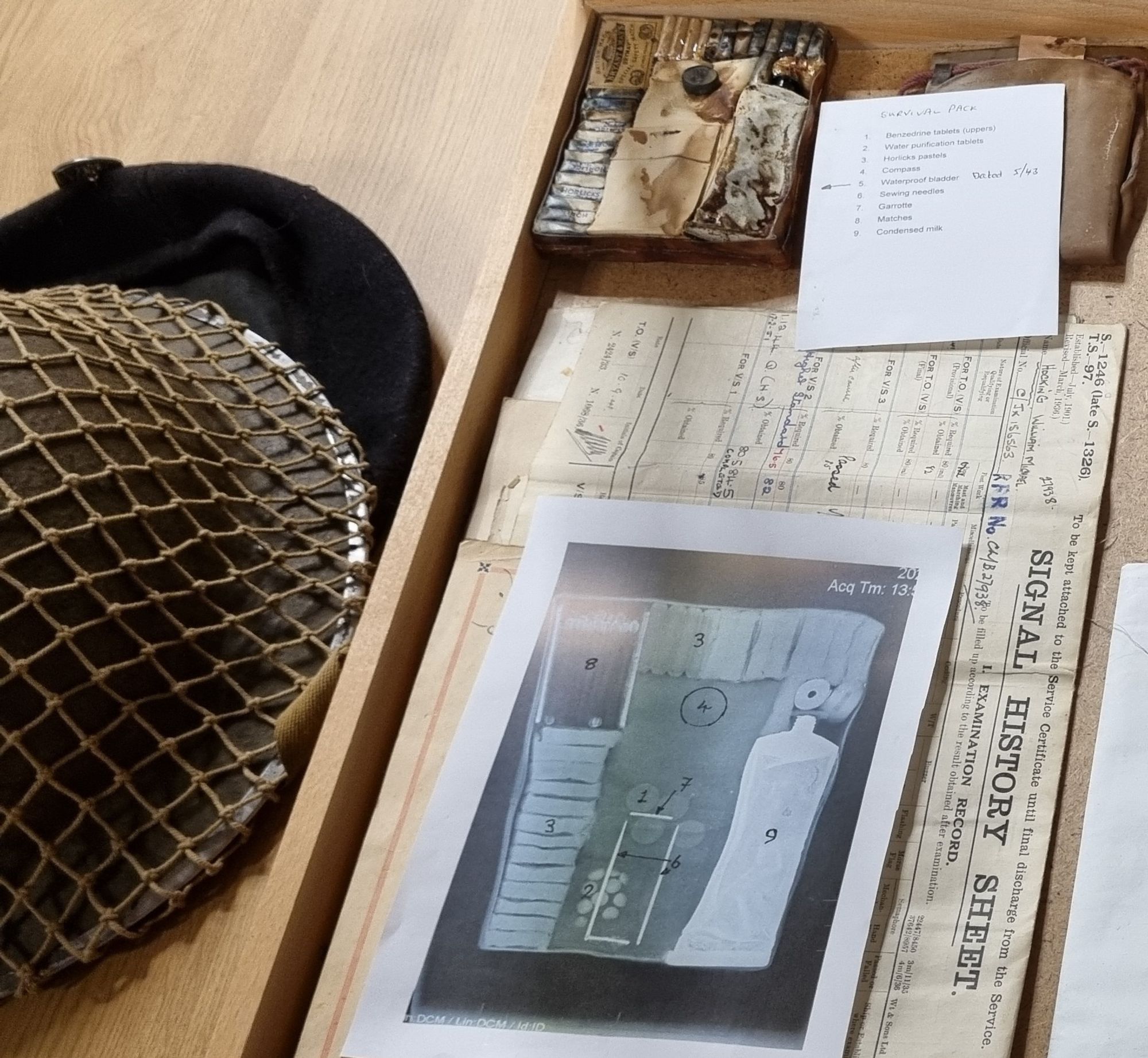 photo of survival pack and list of contents along with a Tommy hat