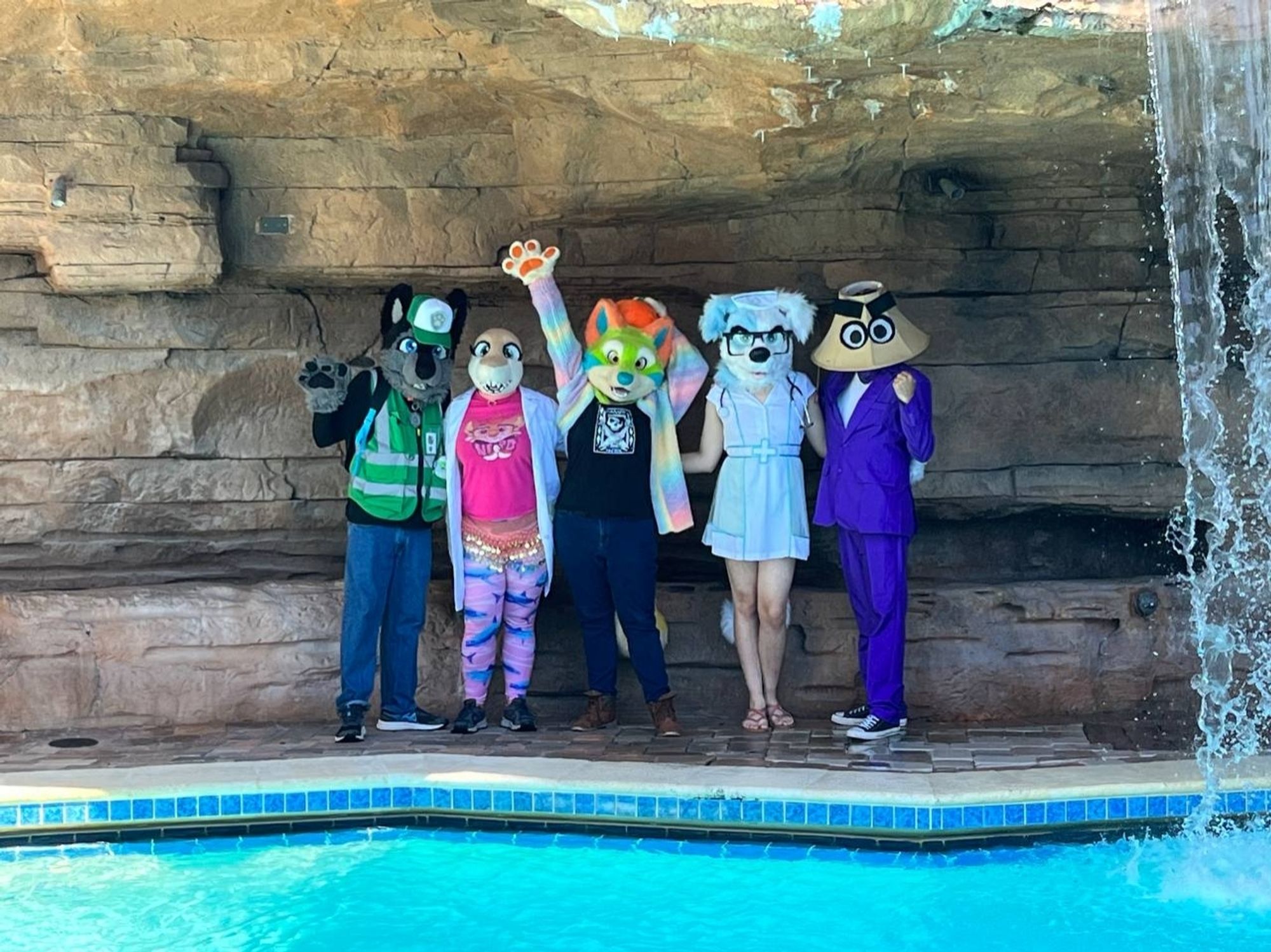 Group of people in fursuits being goofballs standing at the edge of a pool