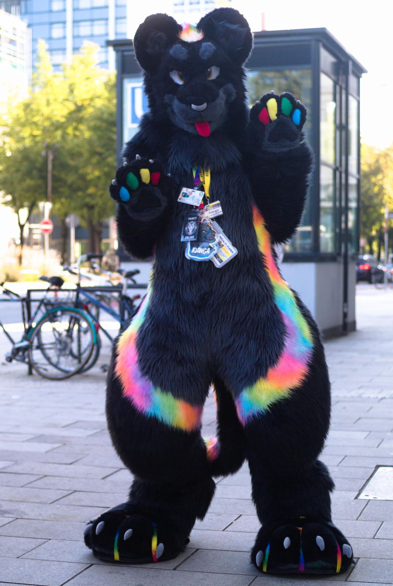 Photo of me in black jaguar fursuit in the city of Hamburg, paws held up showing colorful beans. (Credit: Isolectra)