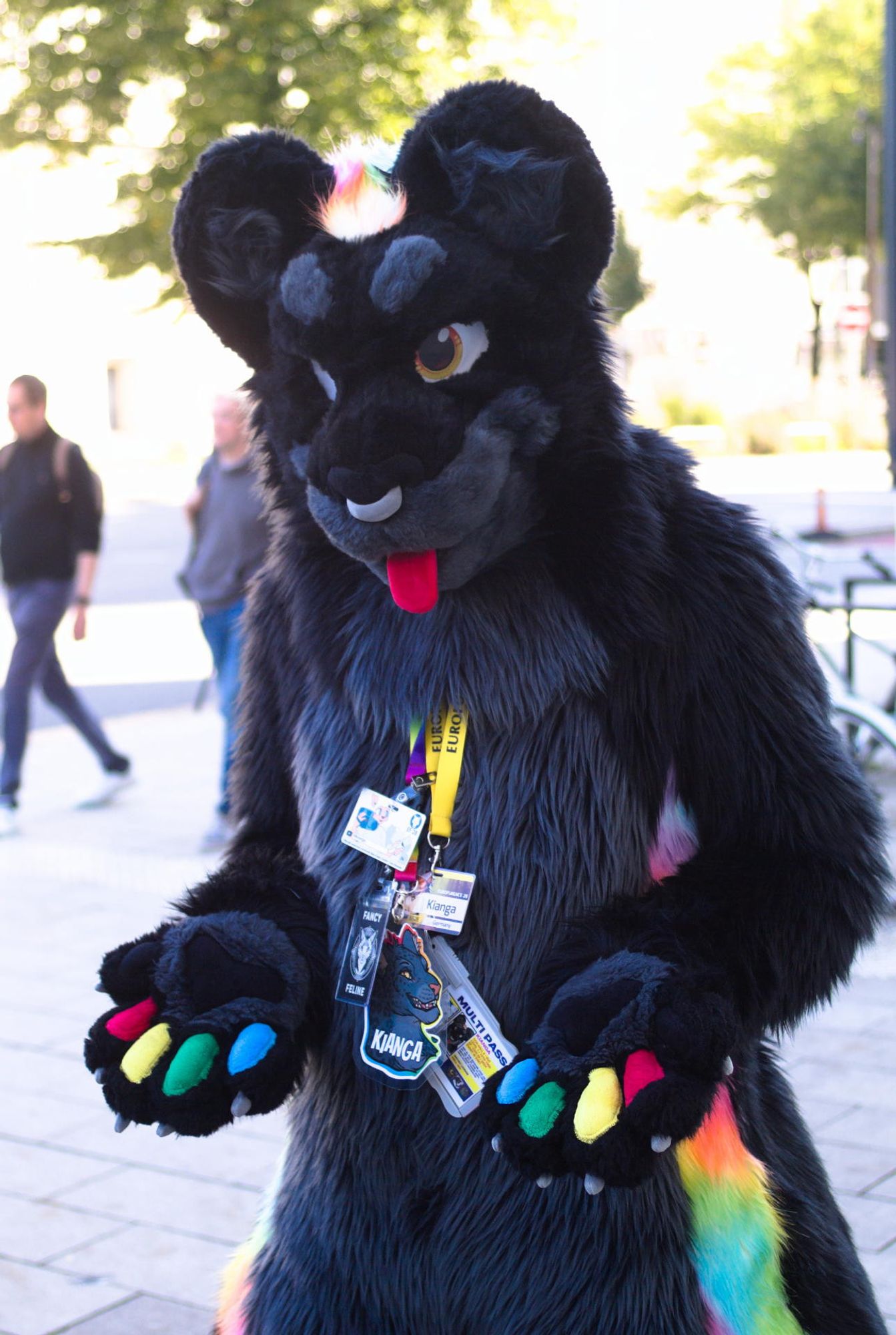 Photo of me in black jaguar fursuit in the city of Hamburg, arms lower but palms and paw pads facing up. (Credit: Isolectra)