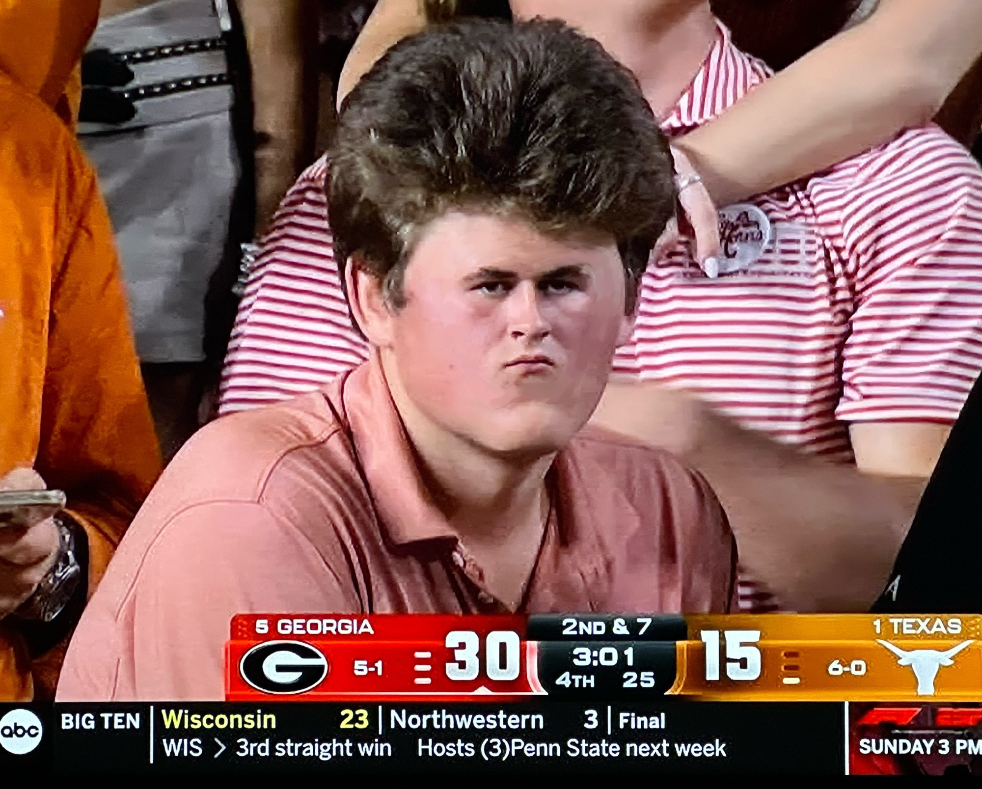 TV capture of an ABC stream. A man with a very small face and a big hairdo. (the face is clearly shrinked to enhance the powerful hair style)