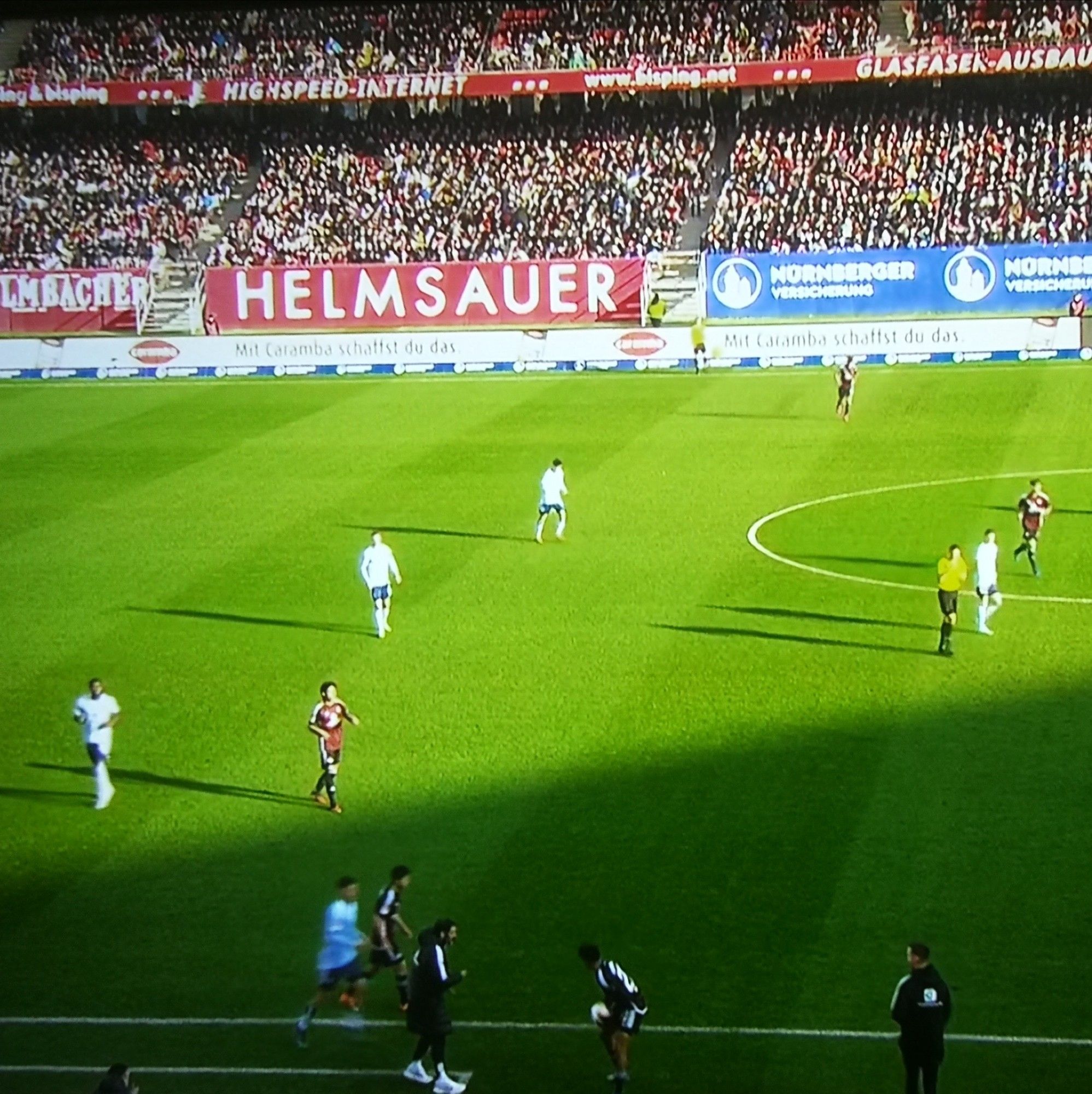 Szene aus Nürnberg v HSV. Werbetafel HELMSAUER.