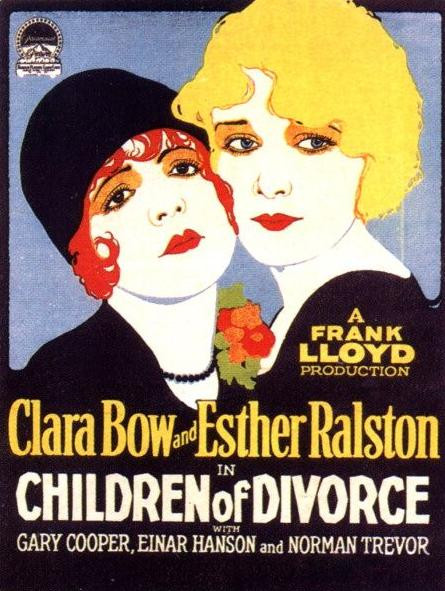 A poster for the film. We can see two women close together. One of them has short, wavy, red hair and is wearing a black hat and a black, long-sleeved dress. The other woman has blond, short, straight hair and is wearing a black, long-sleeved dress. Both women have red lipstick on.