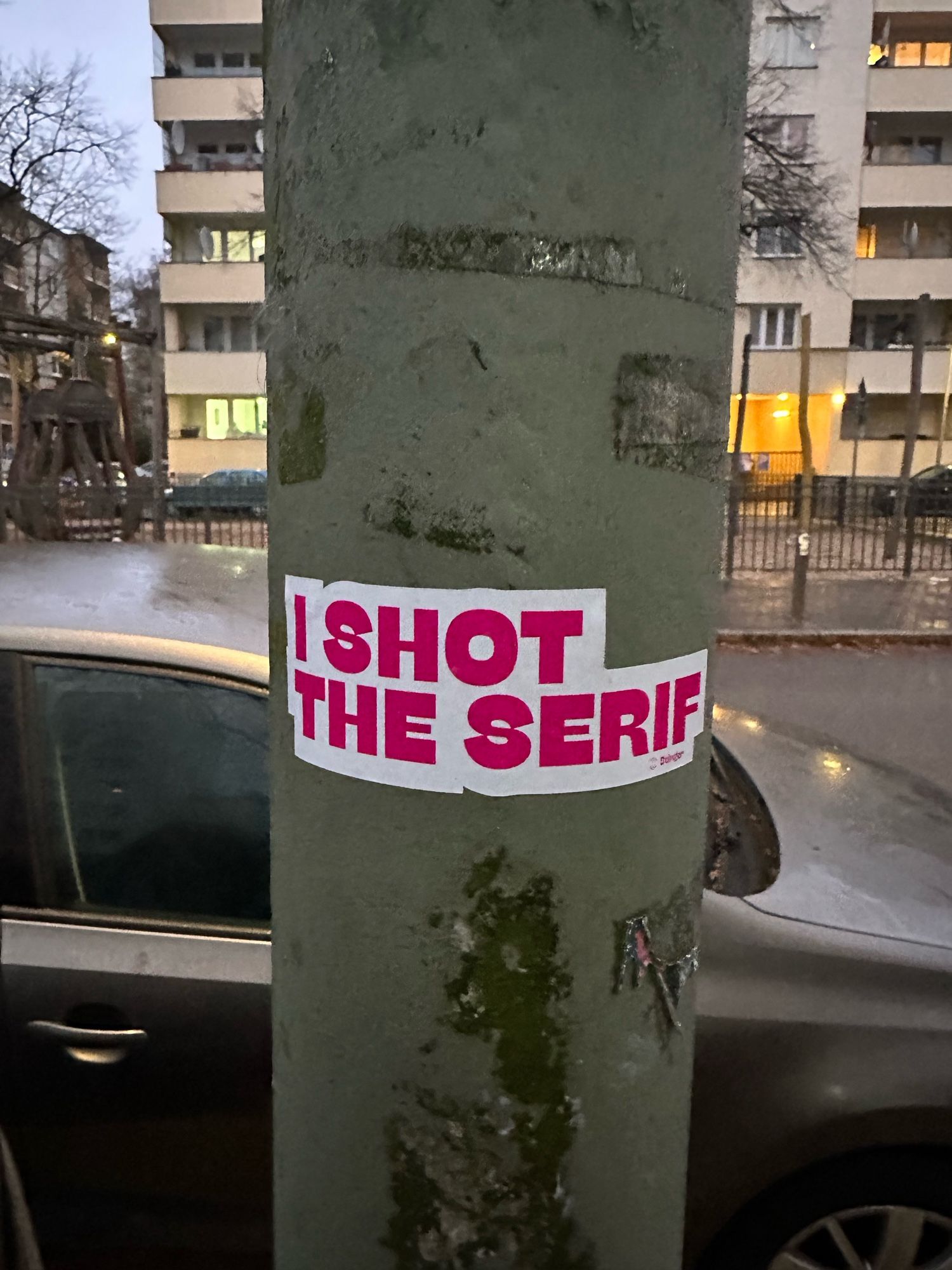 Ein Aufkleber an einem Laternenpfahl mit der Aufschrift „I shot the serif.“