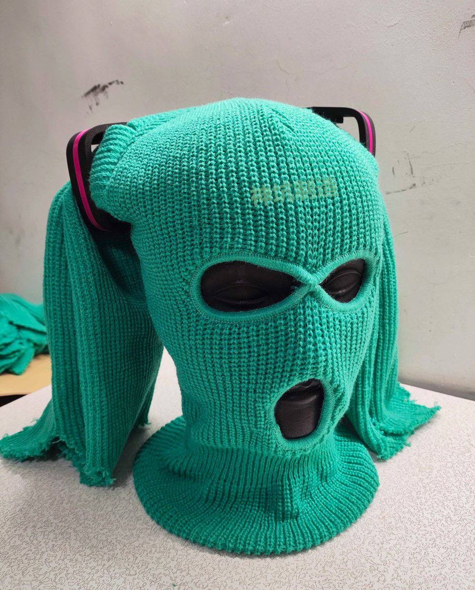 A skimask (shiesty) made to look like hatsune mikus hairstyle on a model head