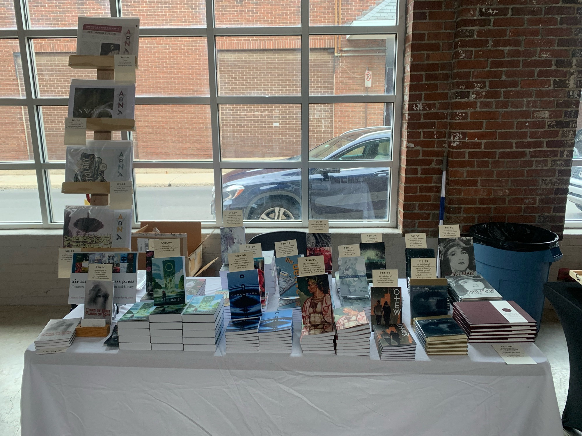 The table of Air and Nothingness Press books in a large garage style space