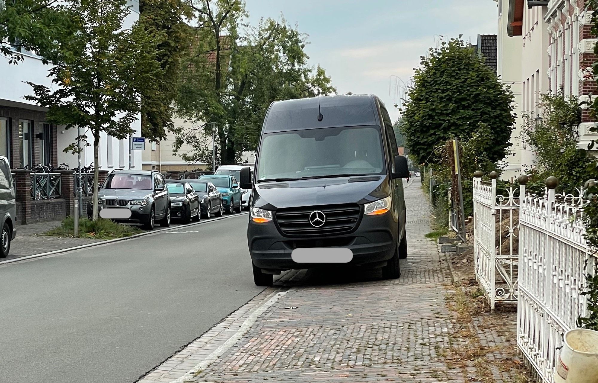 Auf Gehweg geparktes KFZ (Transporter), das den Gehweg nahezu vollständig blockiert.