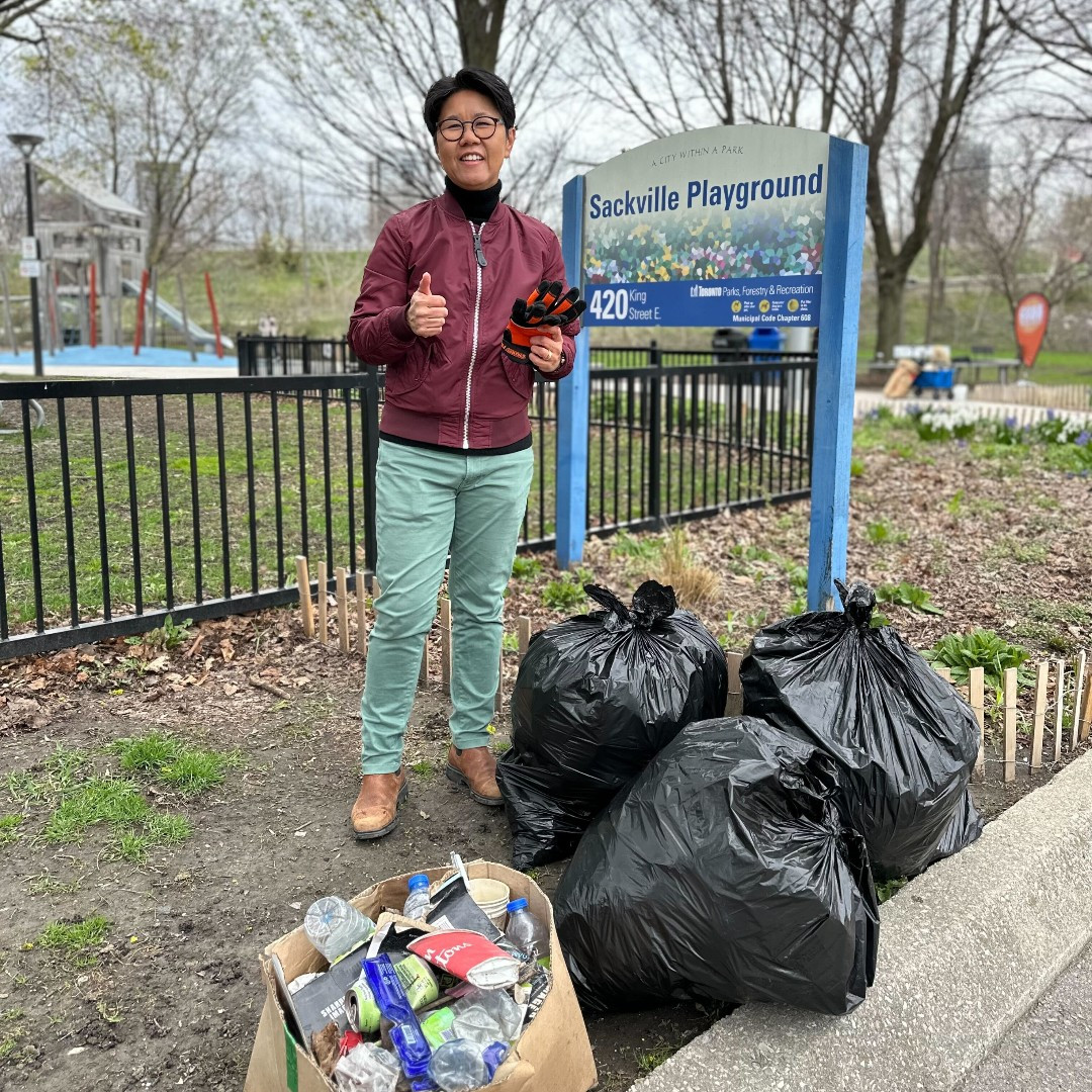 MPP Kristyn Wong-Tam by sackville playground showing off three bags of garbage they and volunteers gathered