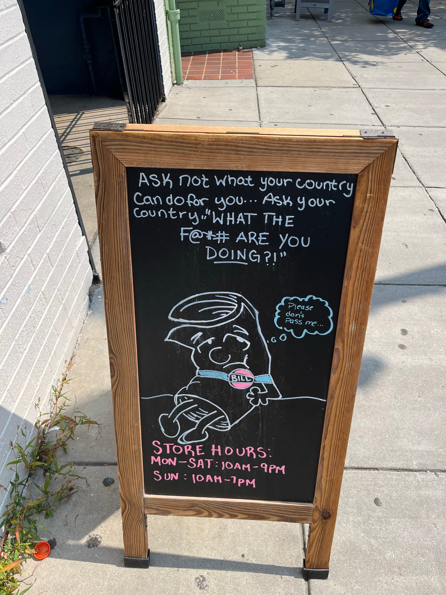 Photo shows chalk sign outside Solid State Books with a parody of the Bill from Schoolhouse Rock. Words at top read “Ask not what your country can do for you… Ask your country ´WHAT THE F@*# ARE YOU DOING?!’”

Bill has thought bubble reading “Please don’t pass me…”

Bottom of sign shows store hours:
Mon–Sat: 10AM–9PM
Sun: 10AM–7PM