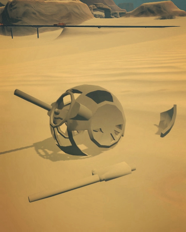 A jettisoned ball turret from a B17 bomber lies sunken into desert sands.