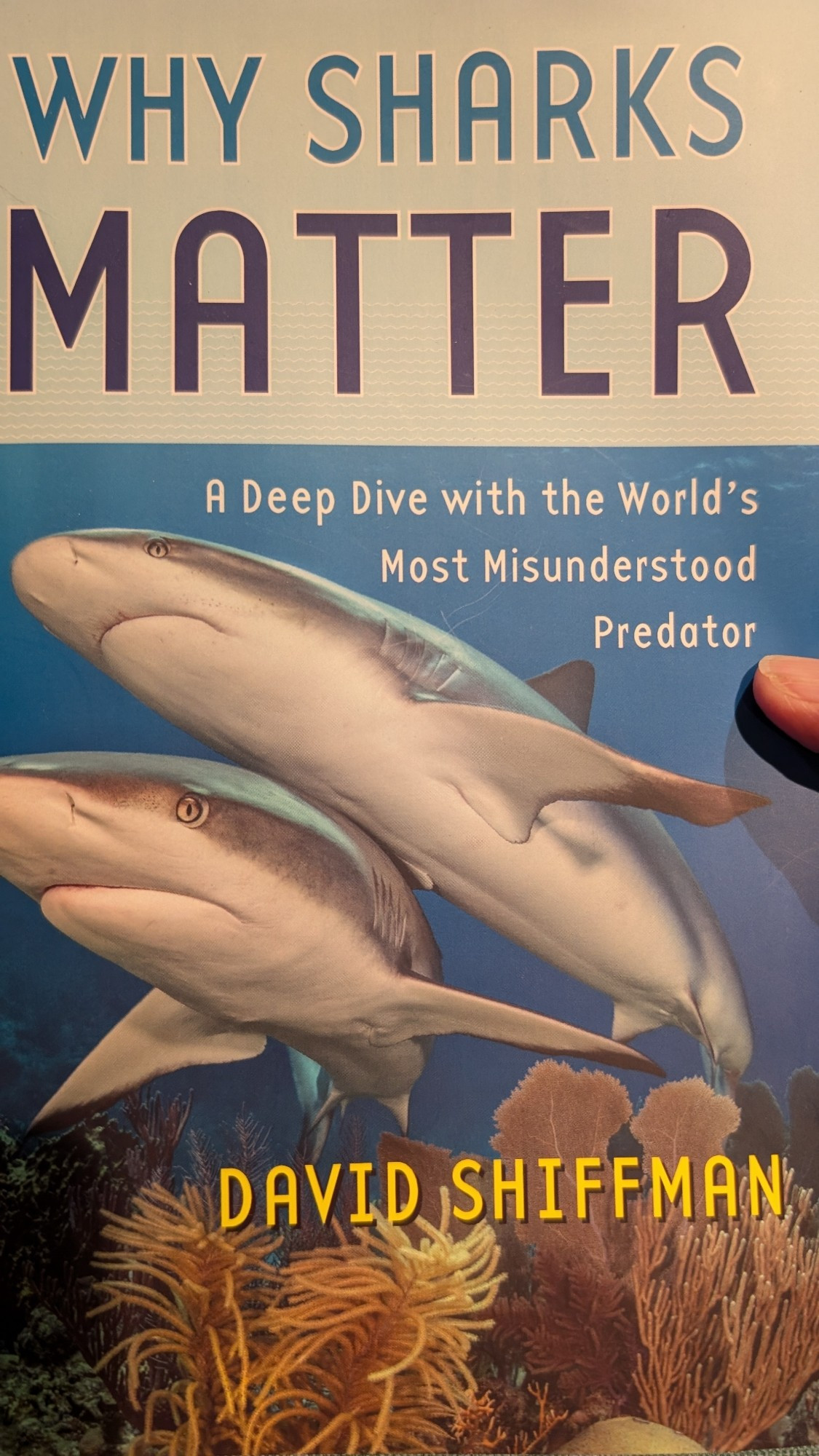 Cover of David Shiffmans book Why Sharks Matter, a deep dive with the world's most misunderstood predator. It has two sharks swimming over coral