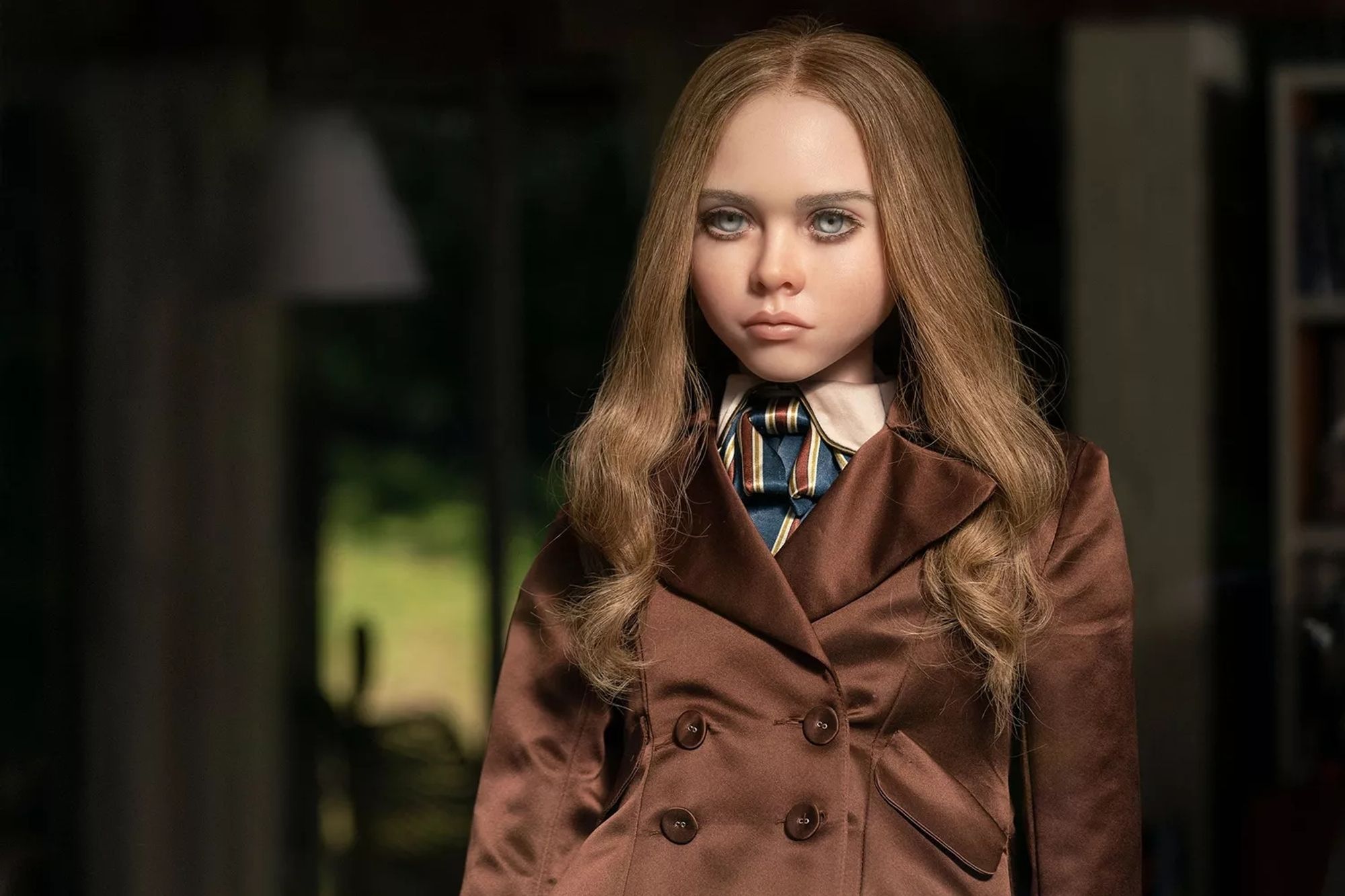 A picture of a blonde female doll wearing a smart looking jacket.