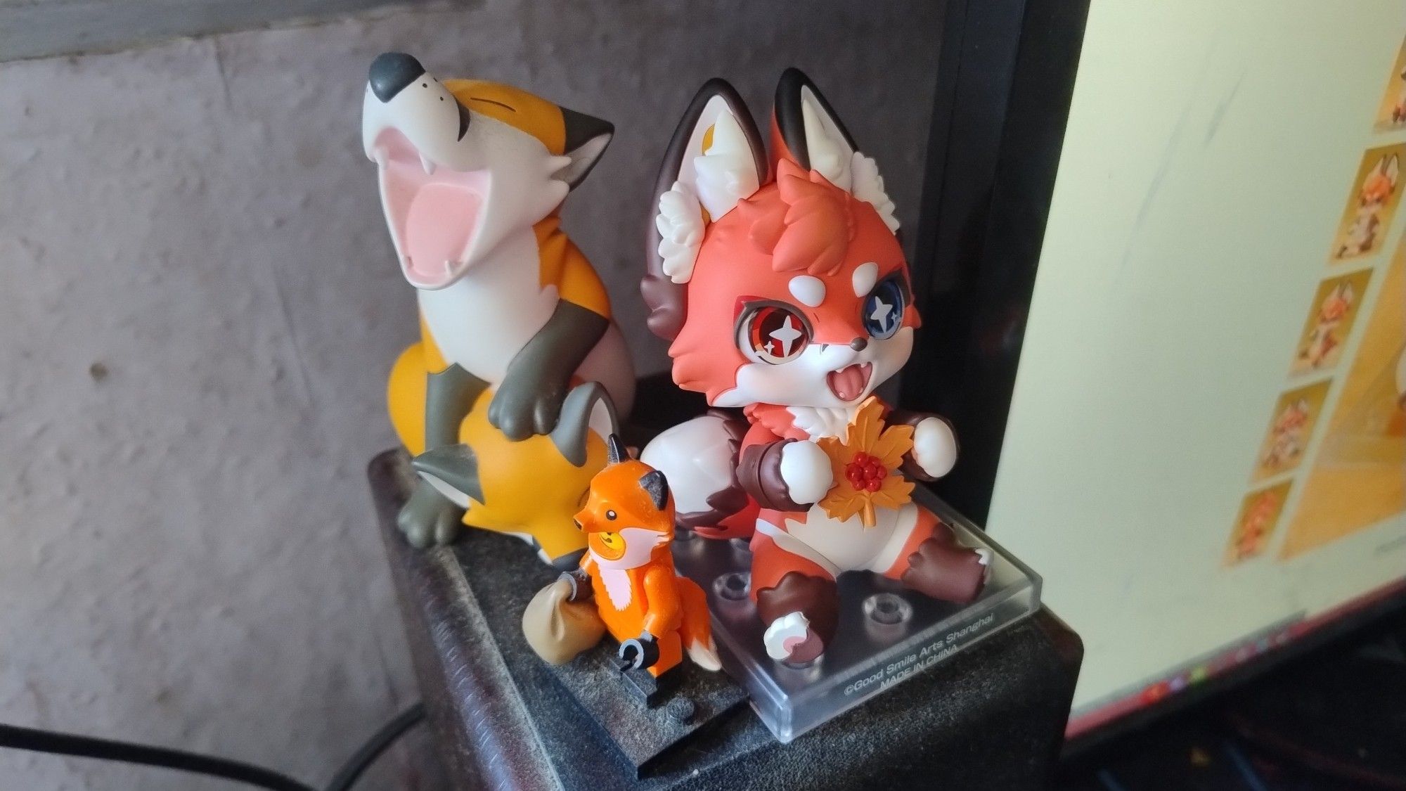 A photo showing a Nenderoid River figure placed on top of a PC speaker alongside a Foxfox vinyl figure and a Lego Minifigure dressed as a fox.