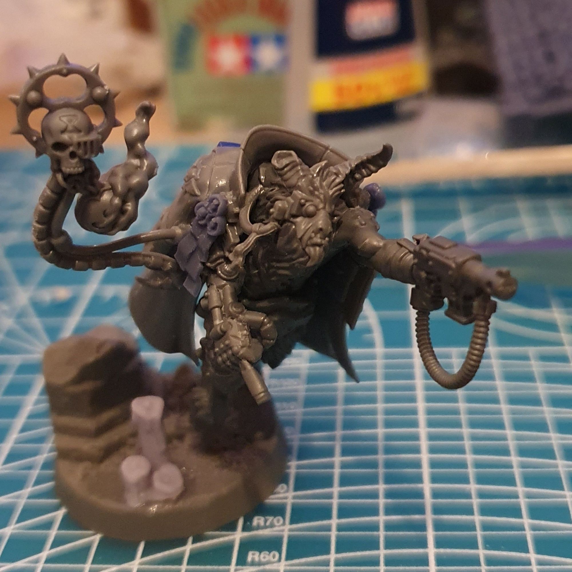 A kitbashed 40K miniature using a fellgor beastman body and a tempestus scion command squad overcoat. Extra purity seals via Legion 3D Prints and scenic base by Unreal Wargaming. Bonus: Nork Deddog's massive cigar stub is clenched in his bionic fist