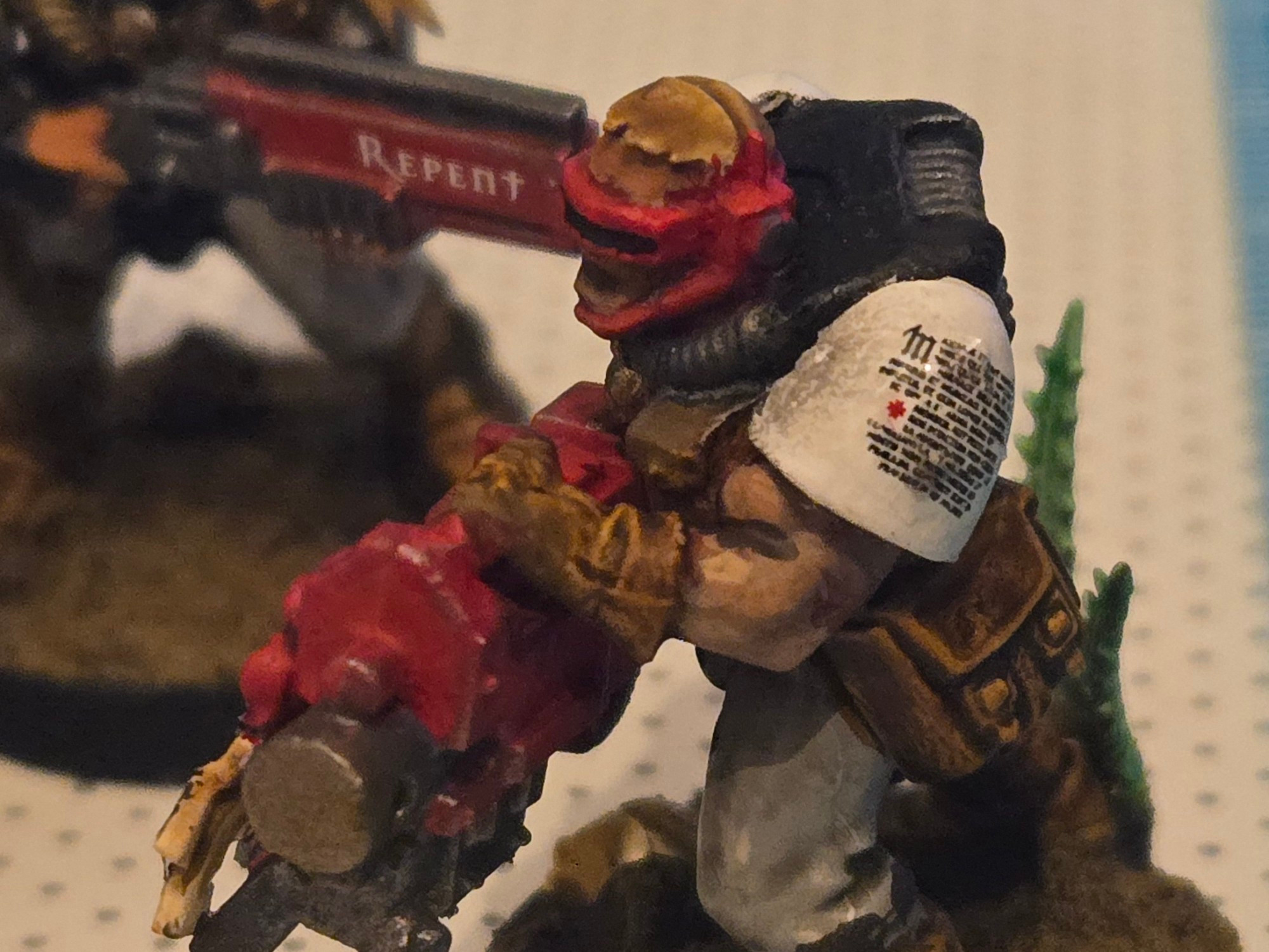 Photo of miniatures I painted, Black Templars scouts with black and white armour and red weaponry. In the foreground a scout with a heavy bolter has a decal of religious script on his shoulder. In the background, the barrel or a scout's shotgun has a decal with the word "REPENT" in all caps.