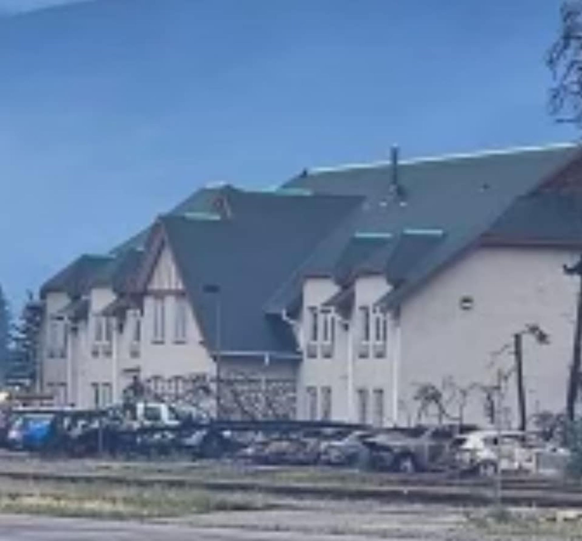 Photo of the CN Bunkhouse in Jasper, shown as safe, with burned cars