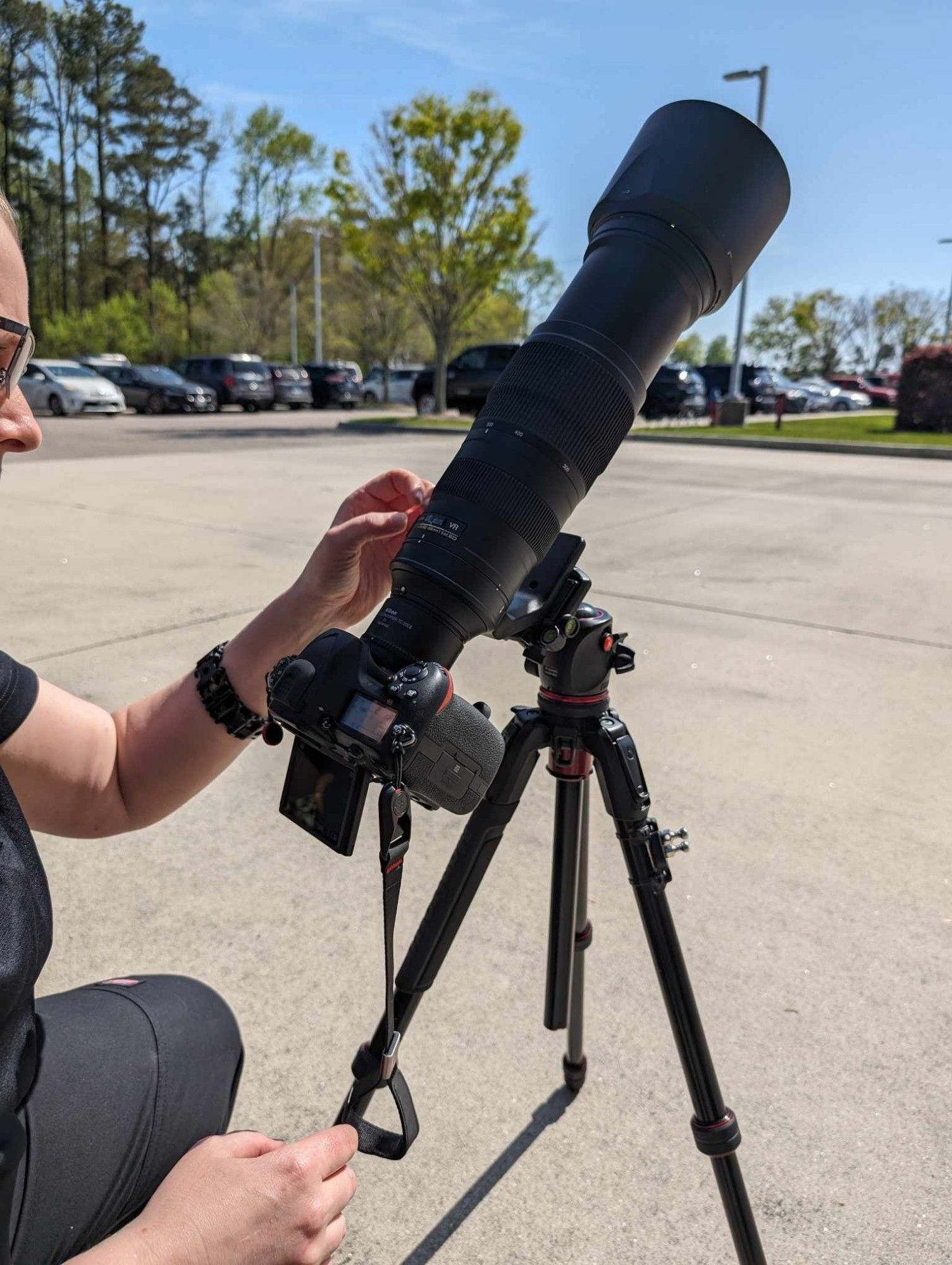 A picture of a camera set up (Nikon d500 with a Nikkor 200-500mm on an aspherical 2X teleconverter) taking pictures of the eclipse.