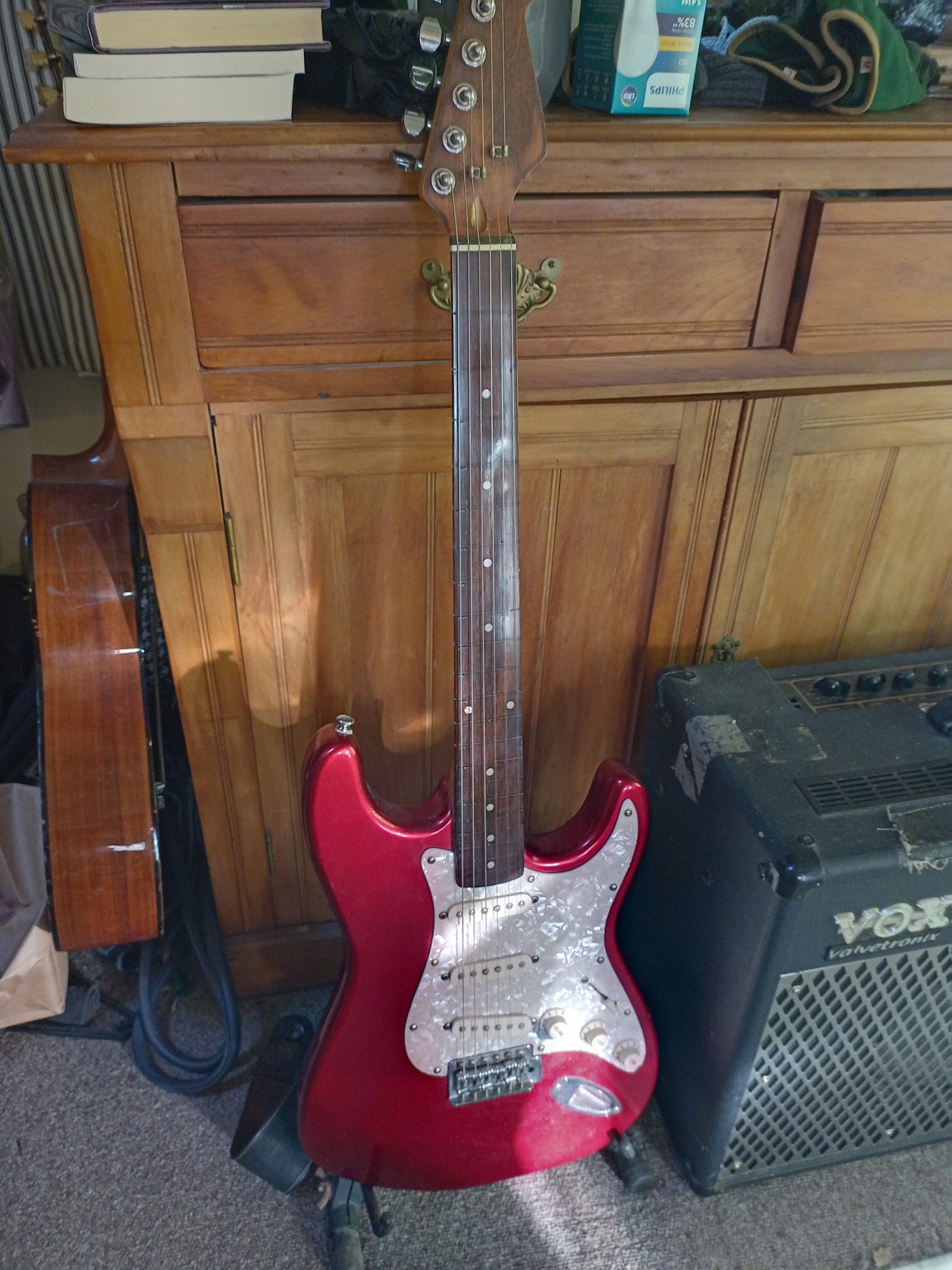 A red fretless Stratocaster guitar.