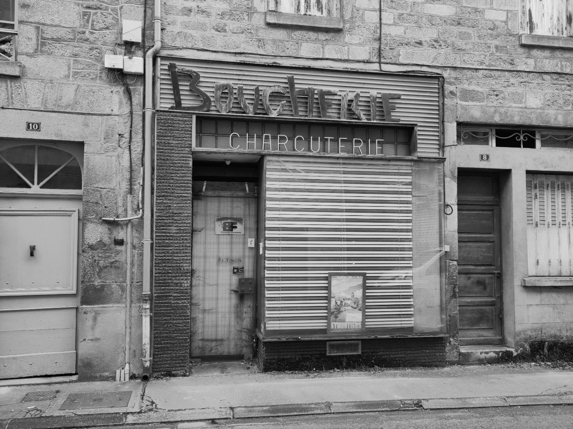 Deventure d'une boucherie dont l'enseigne a perdue quelques lettres. Photographie noir et blanc