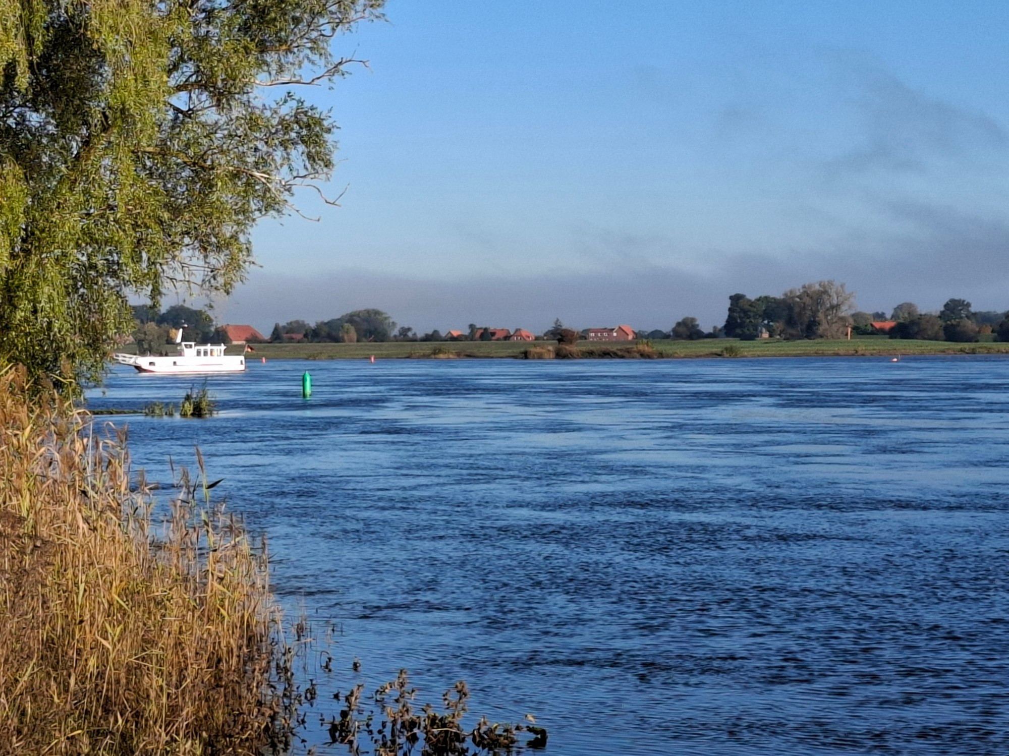 Eine kleine Fähre nähert sich dem diesseitigen Ufer.