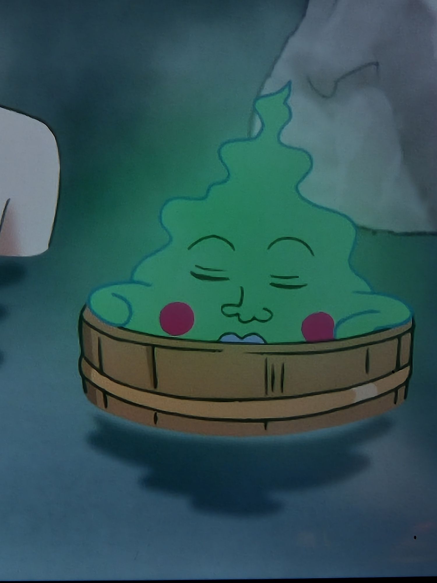 Dimple, a spirit from the show, Mob Psycho, relaxes in a small wooden bucket floating in a hot spring bath.