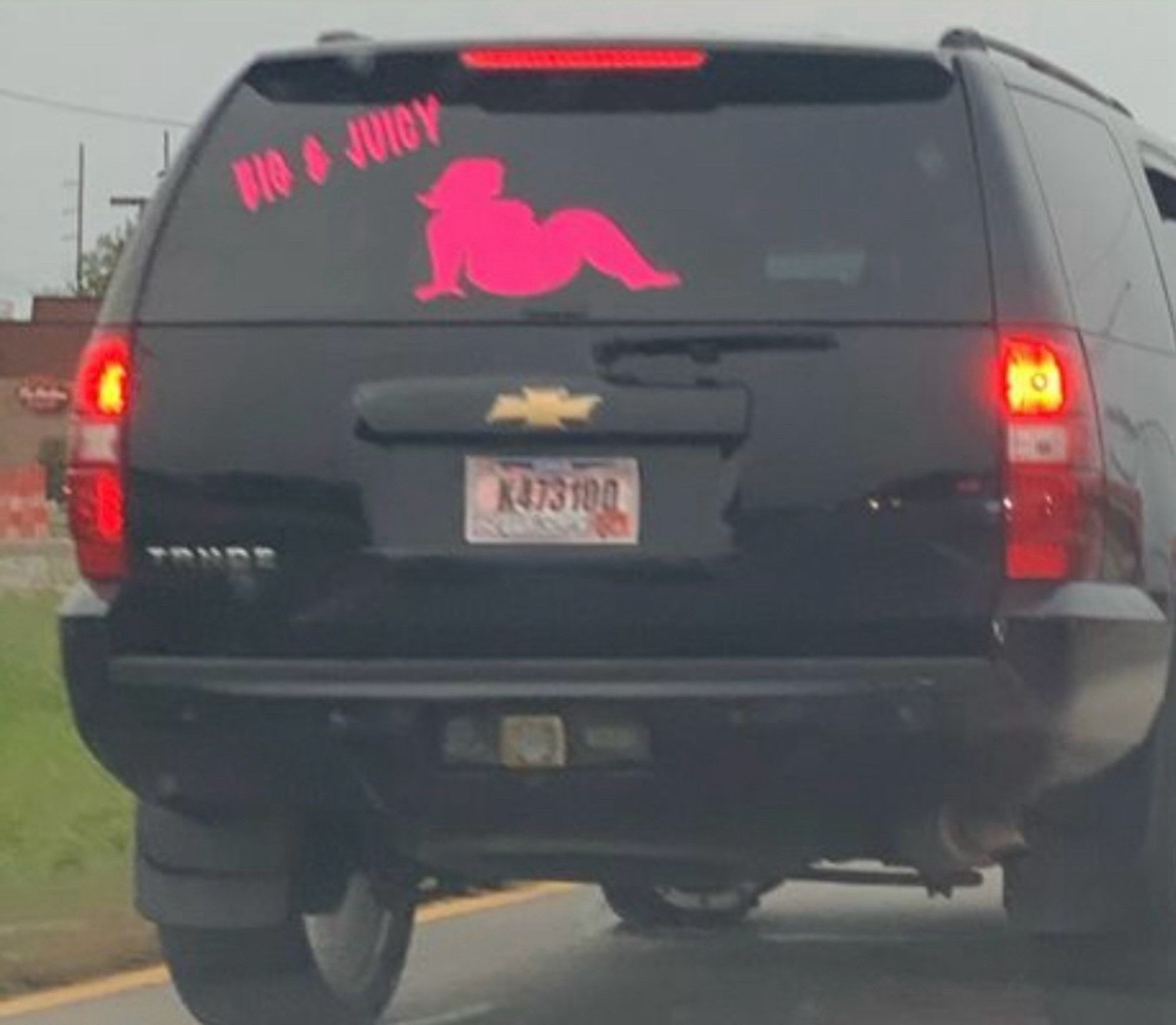 Black SUV with a hot pink decal of a fat woman’s silhouette + the words BIG & JUICY