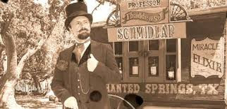 Old photo of the first known snake oil salesman Clark Stanely standing in front of his wagon with a enchanted springs texas sign on it.