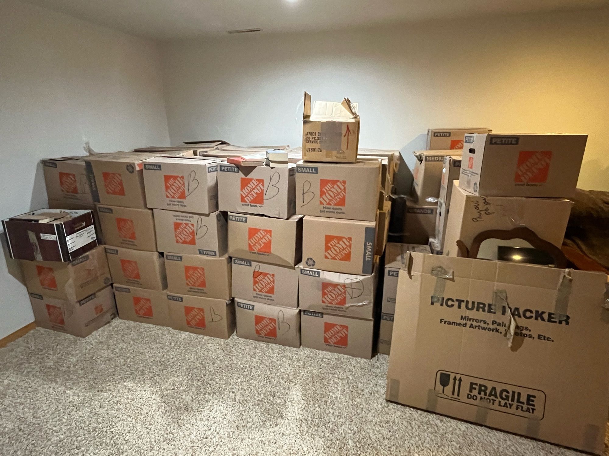 A basement with 5x5x4 section of Home Depot small boxes in a corner. All are filled with books. A relative handful (15?) mixed boxes of housewares. A winter project indeed.