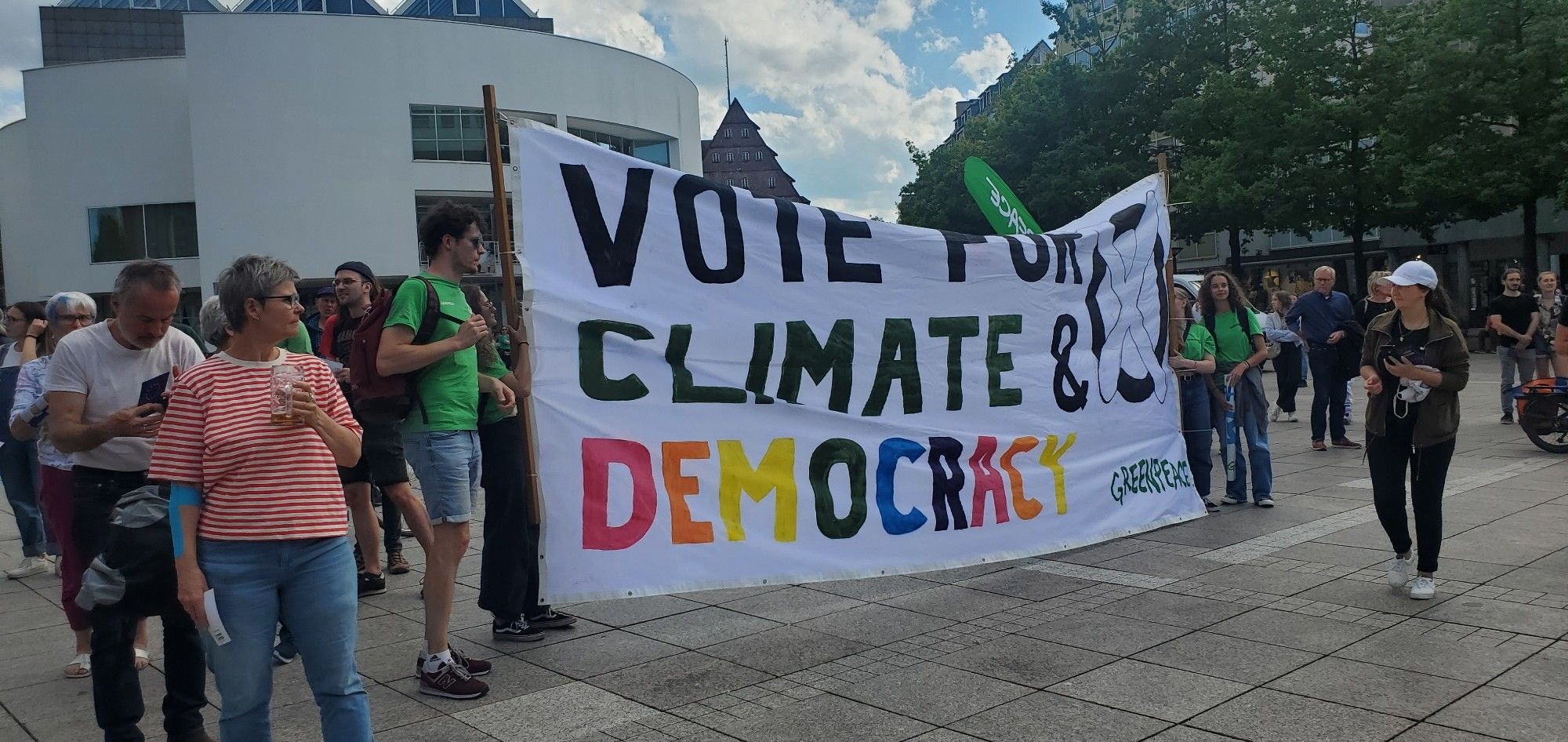 Foto eines großen Banners von Greenpeace Ulm mit der Aufschrift "Vote for Climate and Democracy" auf dem Fest für Vielfalt und Demokratie auf dem Ulmer Münsterplatz.