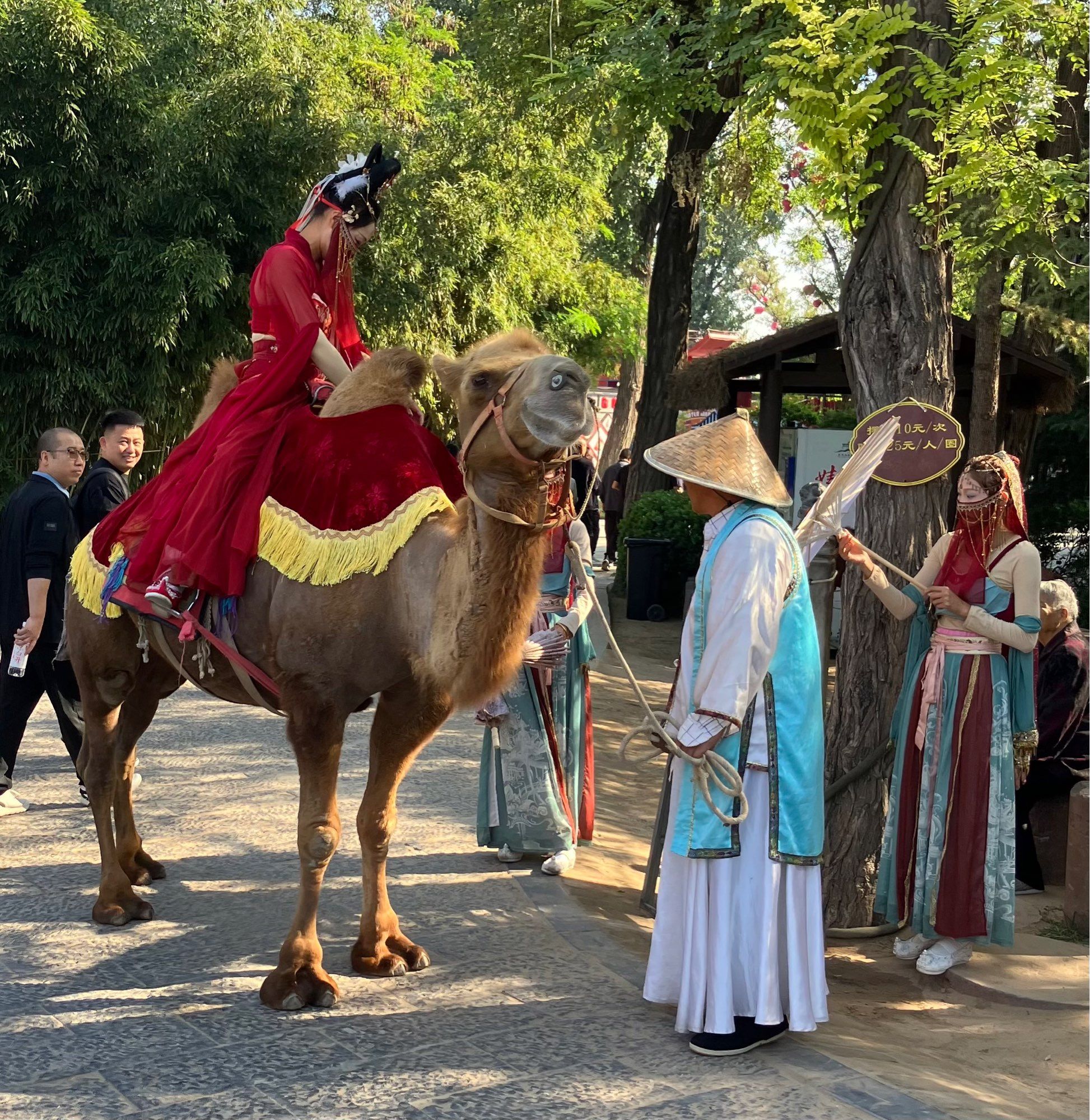 Some actors pretending to be Silk Road merchants, with a girl on a camel dressed in a Persian costume.