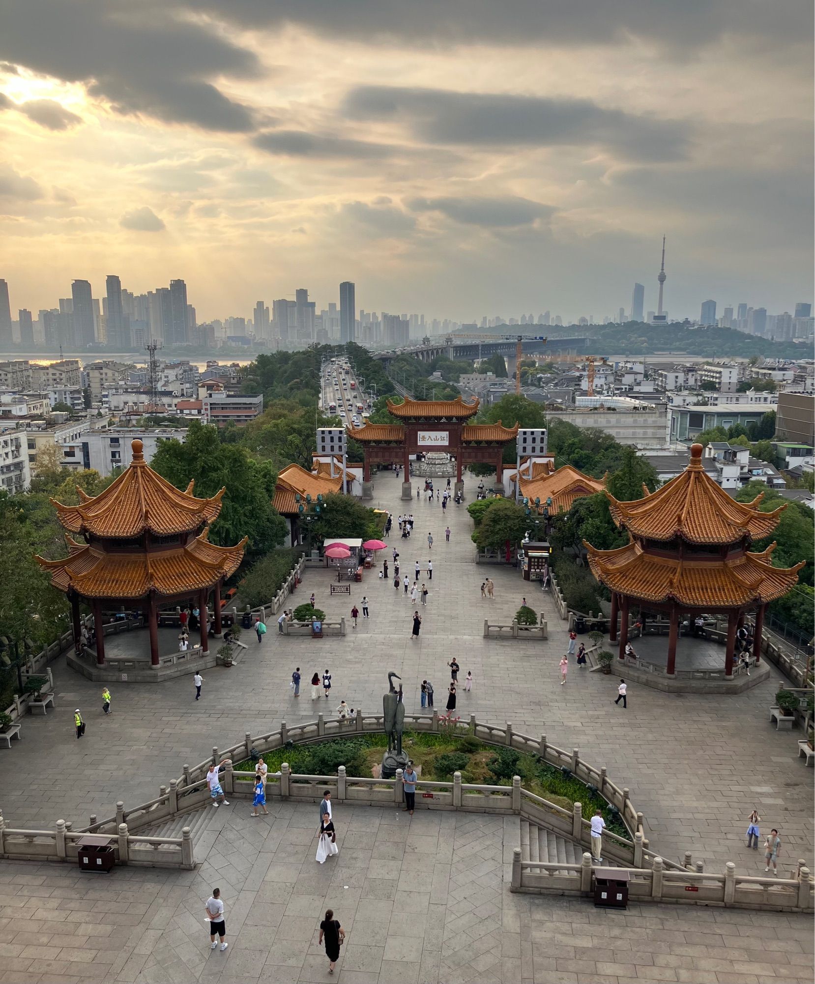 A view of part of Wuhan with skyscrapers in the background. The foreground shows several small pagodas with yellow roof tiles