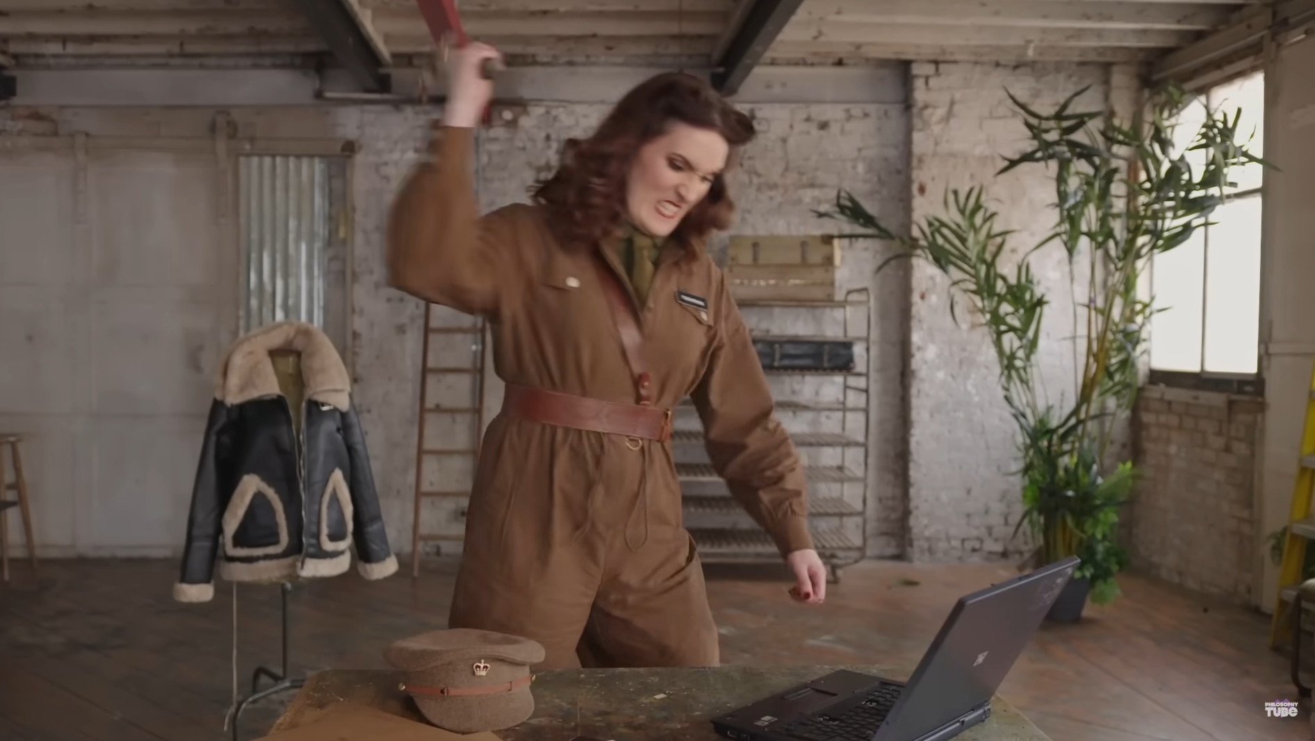 A screenshot of Abigail Thorne smashing her laptop, as it plays Blood on the Risers, during the intro of the Philosophy Tube episode "I Emailed My Doctor 133 Times: The Crisis In The British Healthcare System"