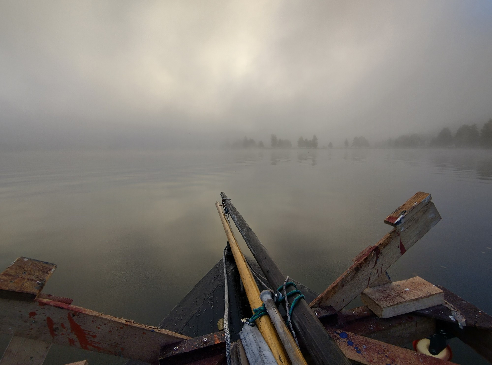 Fog over a lake, seen from the bow of a boat