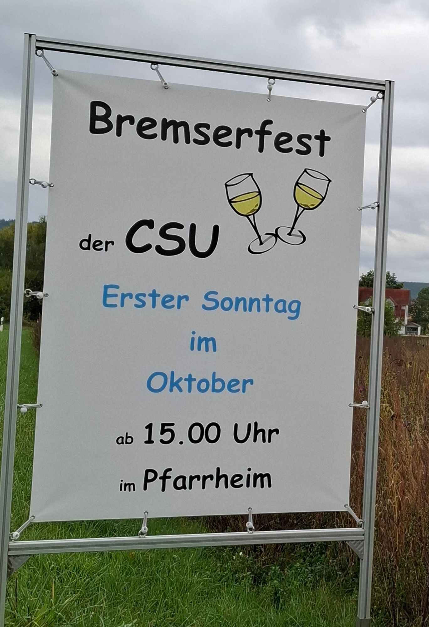 Ein Schild vorm Ortseingang, Nachbardorf. Bremserfest am Sonntag der CSU im Pfarrheim. Mit 2 stilisierten Sektkelchen. Einfach nur widerlich.