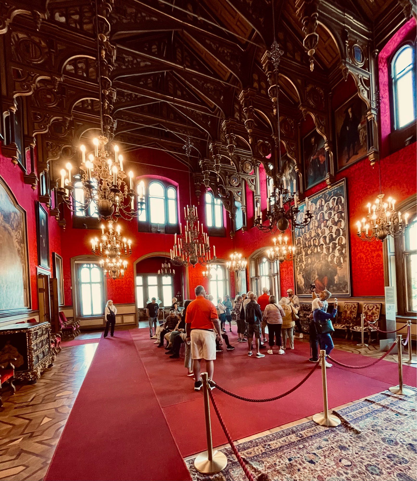 Riduculous double height deep red state room with gilt and chandeliers everywhere, many windows looking out to sea and a coachload of german tourists