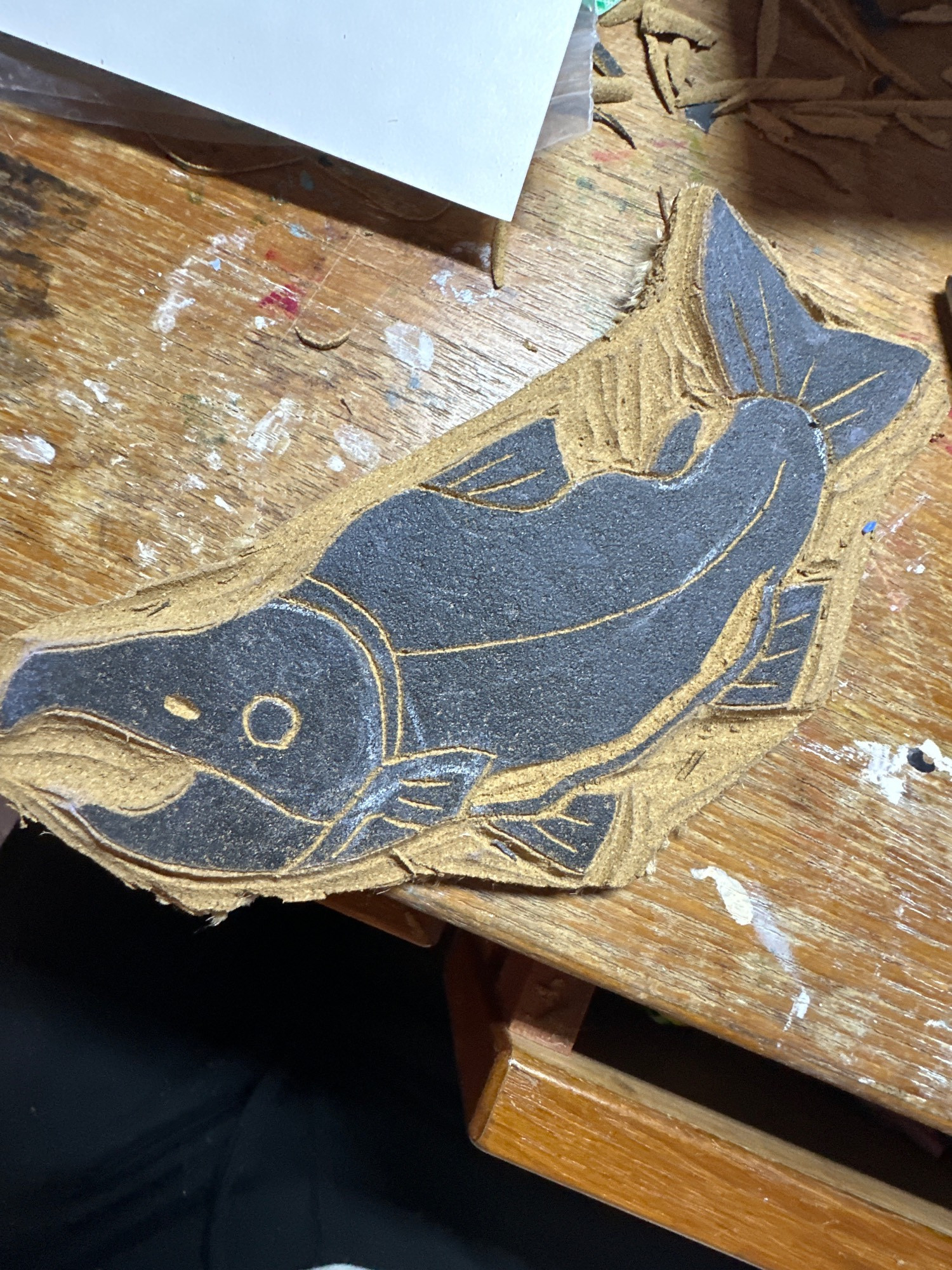 A linocut of a sockeye salmon, the wash is black while the engravings show the cork underneath.