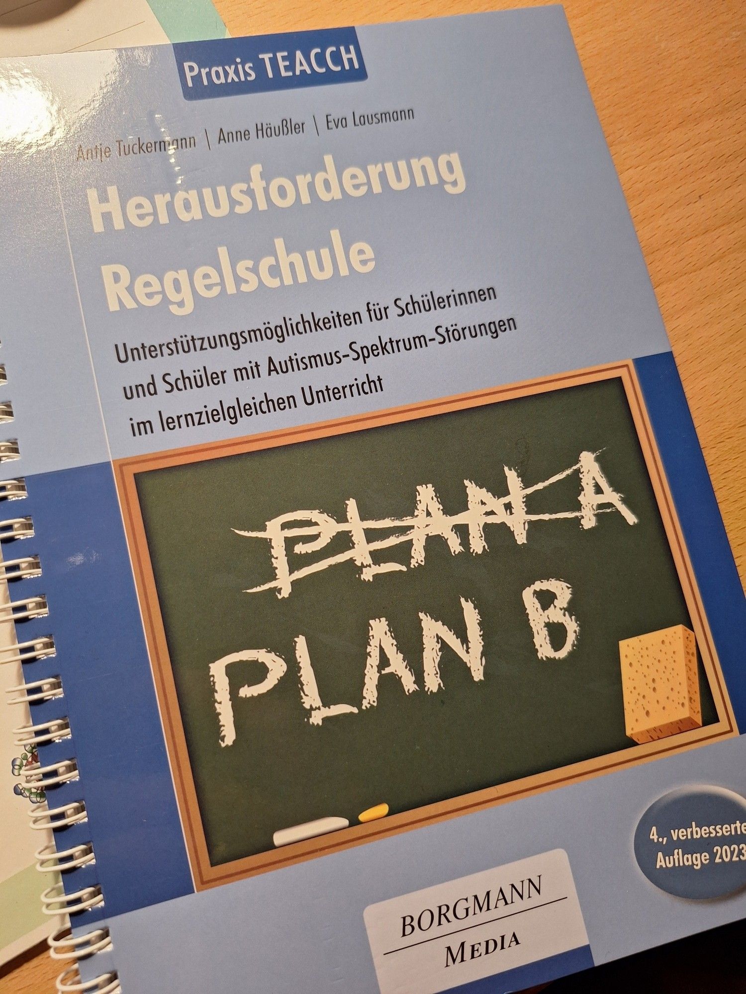 Ein blaues Buch-Cover, Spiralbindung: Antje Tuckermann, Anne Häußler, Eva Lausmann: Herausforderung Regelschule. Unterstützungsmöglichkeiten für Schülerinnen und Schüler mit Autismus-Spektrum-Störungen im lernzielgleichen Unterricht. Praxis Teacch.