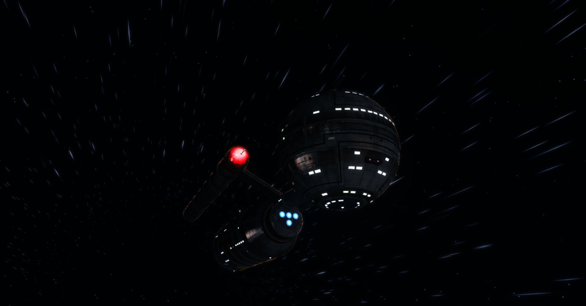 The starship Aegis, a Daedalus class vessel with a spherical primary hull in its forward section and a cylindrical stardrive hull aft.  There are two cylindrical nacelles on either side of the hull with red glowing caps and illumination from flood lights & windows.  Stars streak all around the ship as it moves in a faster-than-light bubble of folding space-time.  The logo in the top left corner is a side profile of the ship reading "Star Trek Aegis."