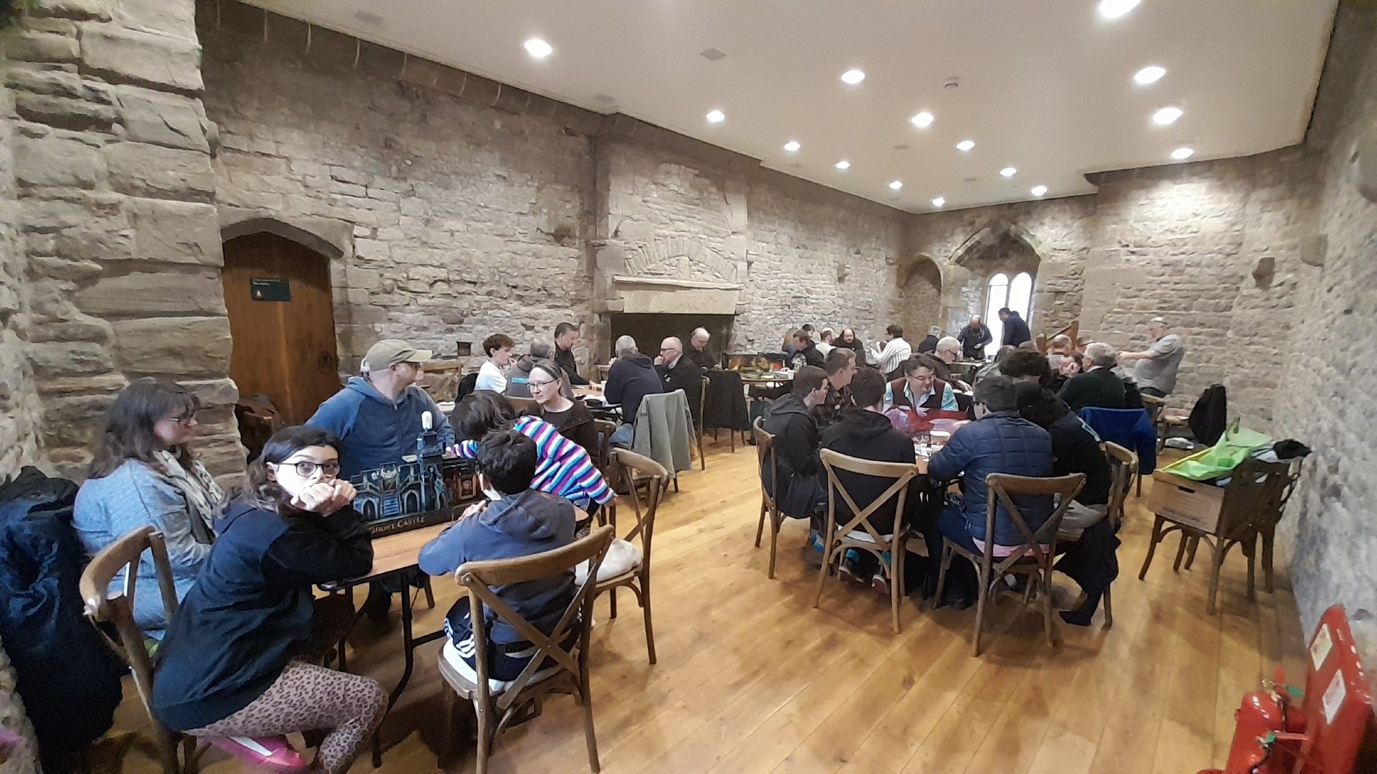 The Earl's Chamber, a medieval stone walled room in Chepstow Castle, filled with gamers from #DotBL 2024