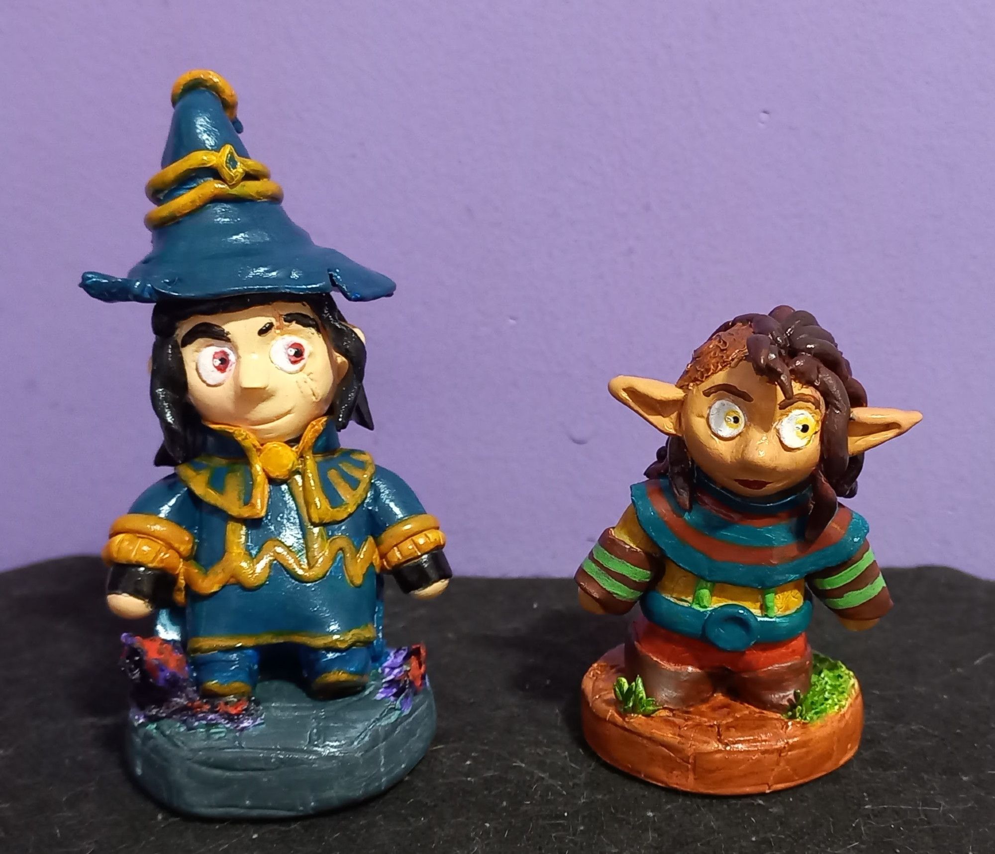 Picture of clay figures of the wizard Mortimer and the elf Veriesin from the webcomic Splitting Image, in indoor light.