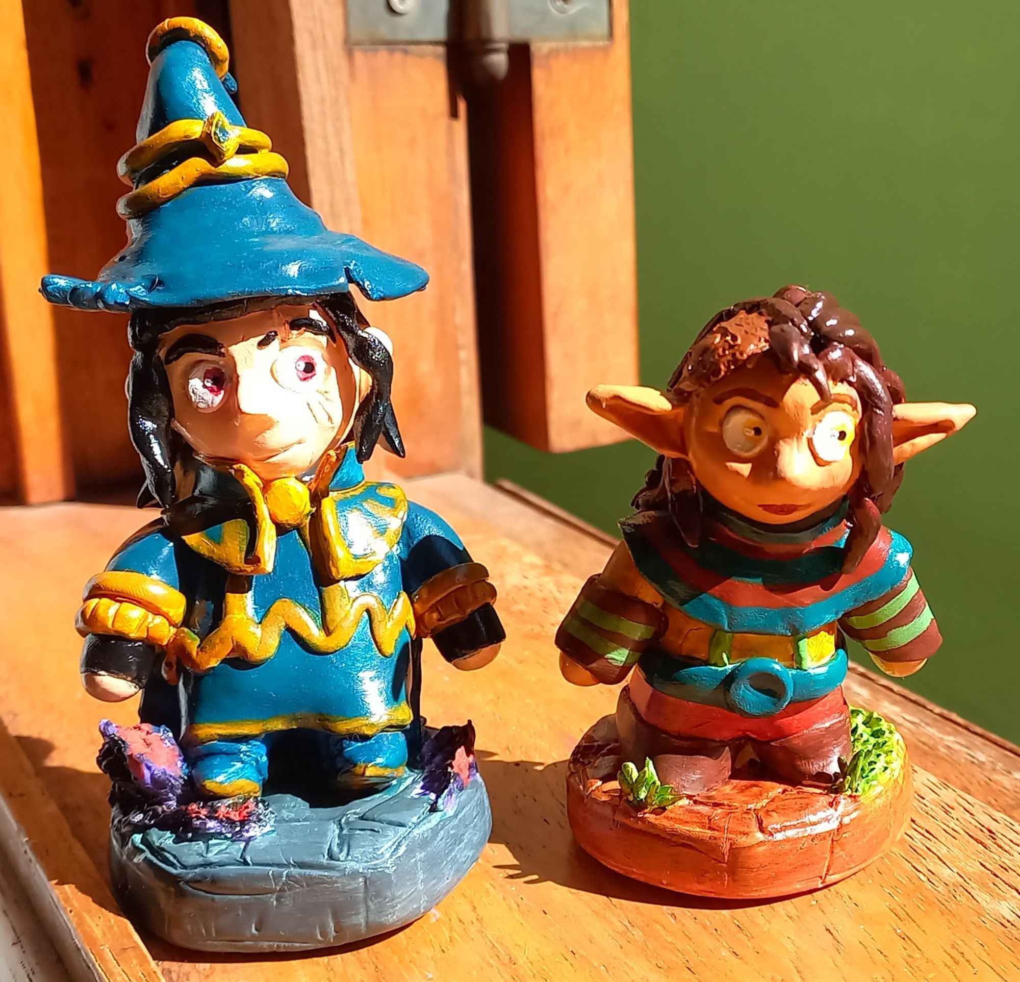 Picture of clay figures of the wizard Mortimer and the elf Veriesin from the webcomic Splitting Image, in sunlight.