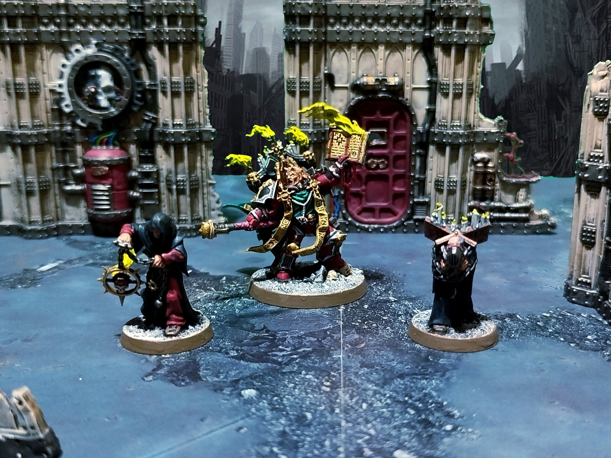 Foto estilo diorama de las miniaturas de un Apóstol Oscuro y dos cultistas en las ruinas de una ciudad imperial.