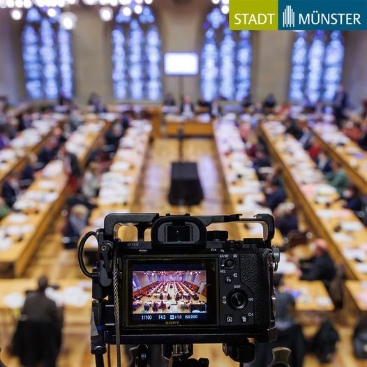 Festsaal des Rathauses in Münster während einer Ratssitzung. Im Vordergrund steht eine filmende Kamera.