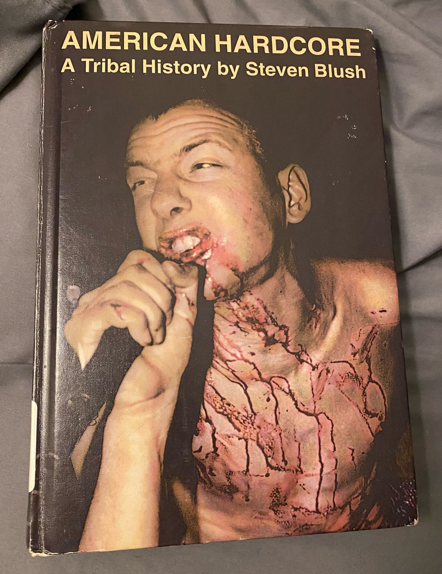 AMERICAN HARDCORE: A Tribal History by Steven Blush. Book cover featuring a bloody young white guy singing into a microphone.